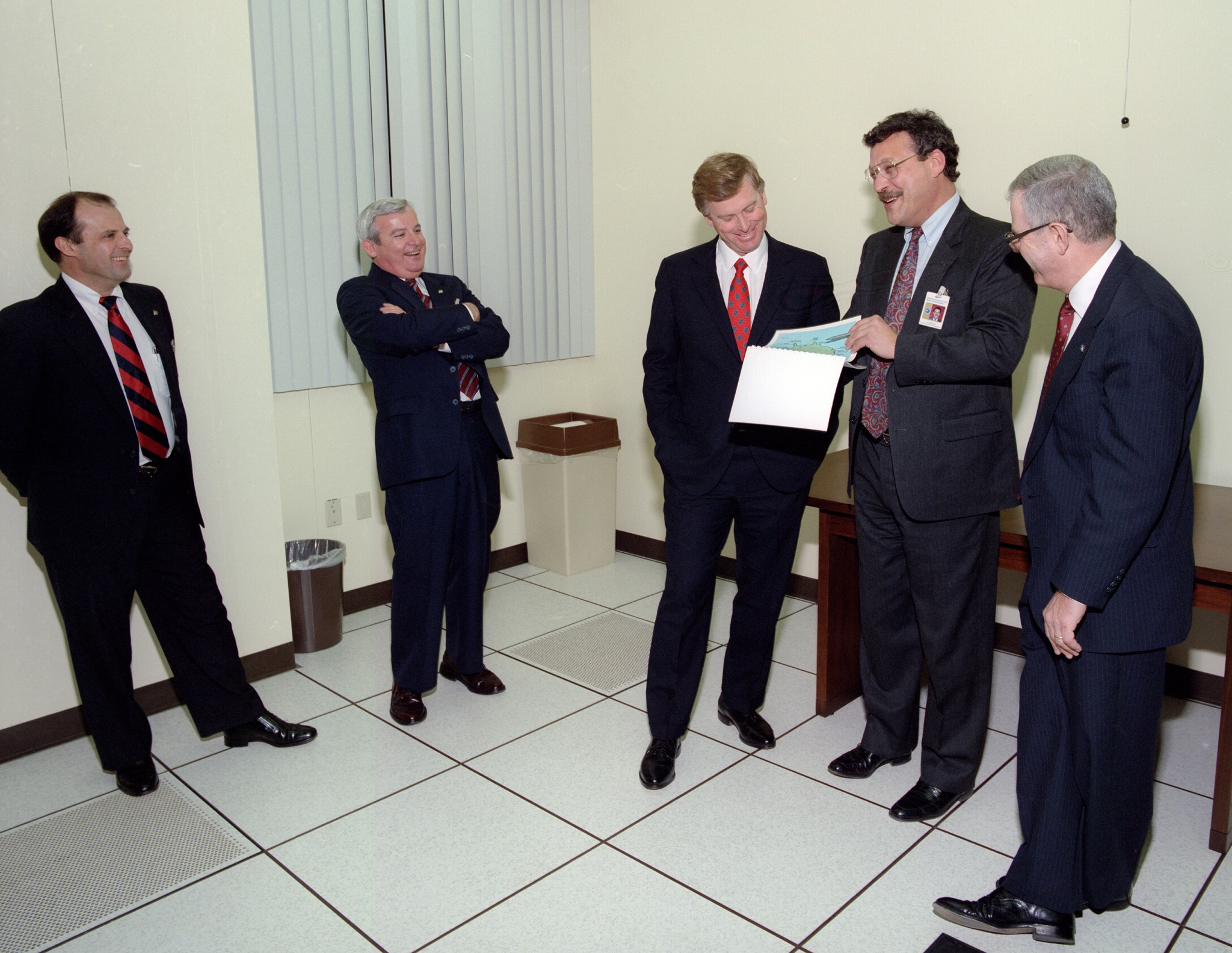 Group of men standing in room.