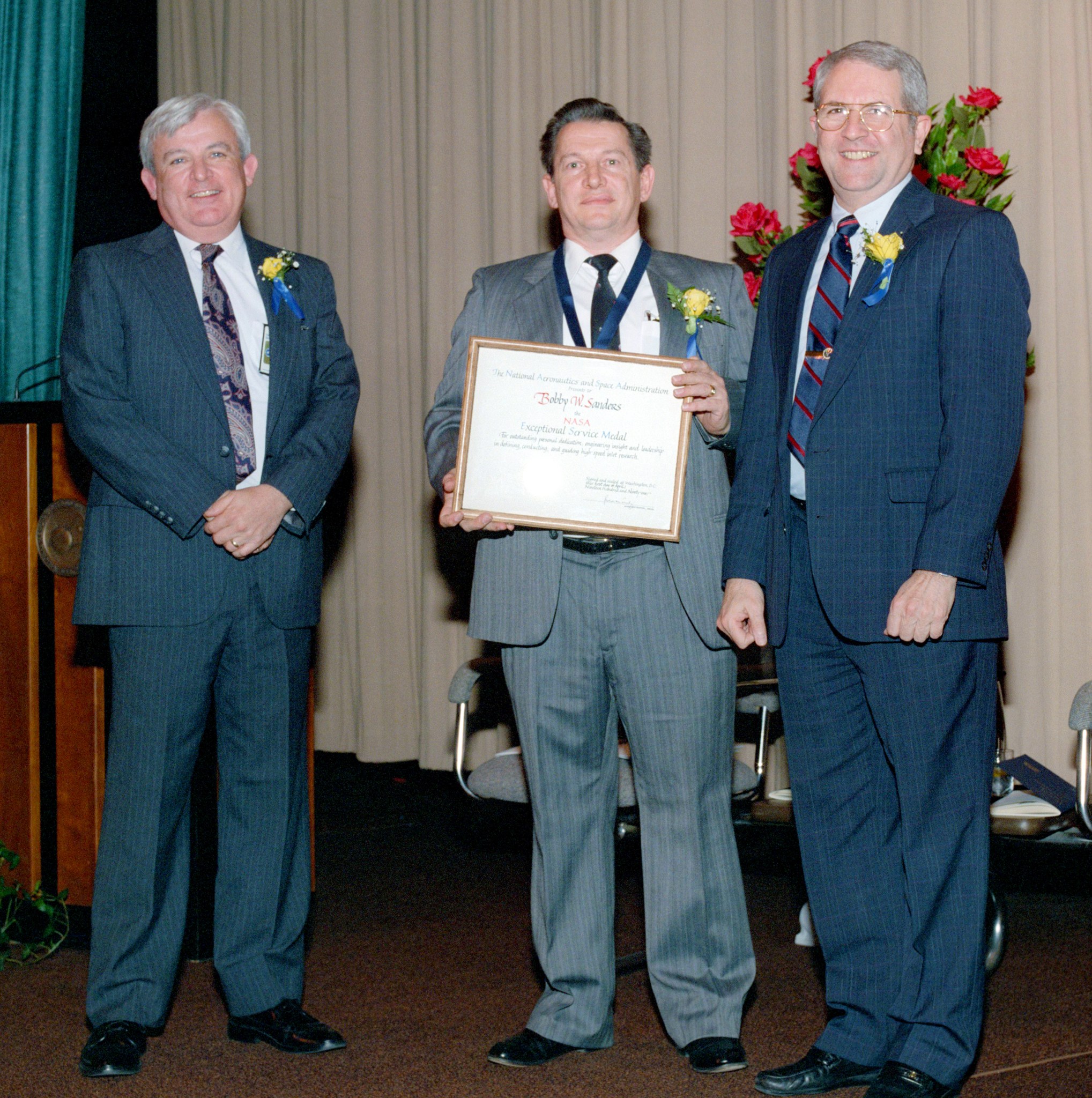 Three men standing with plaque.