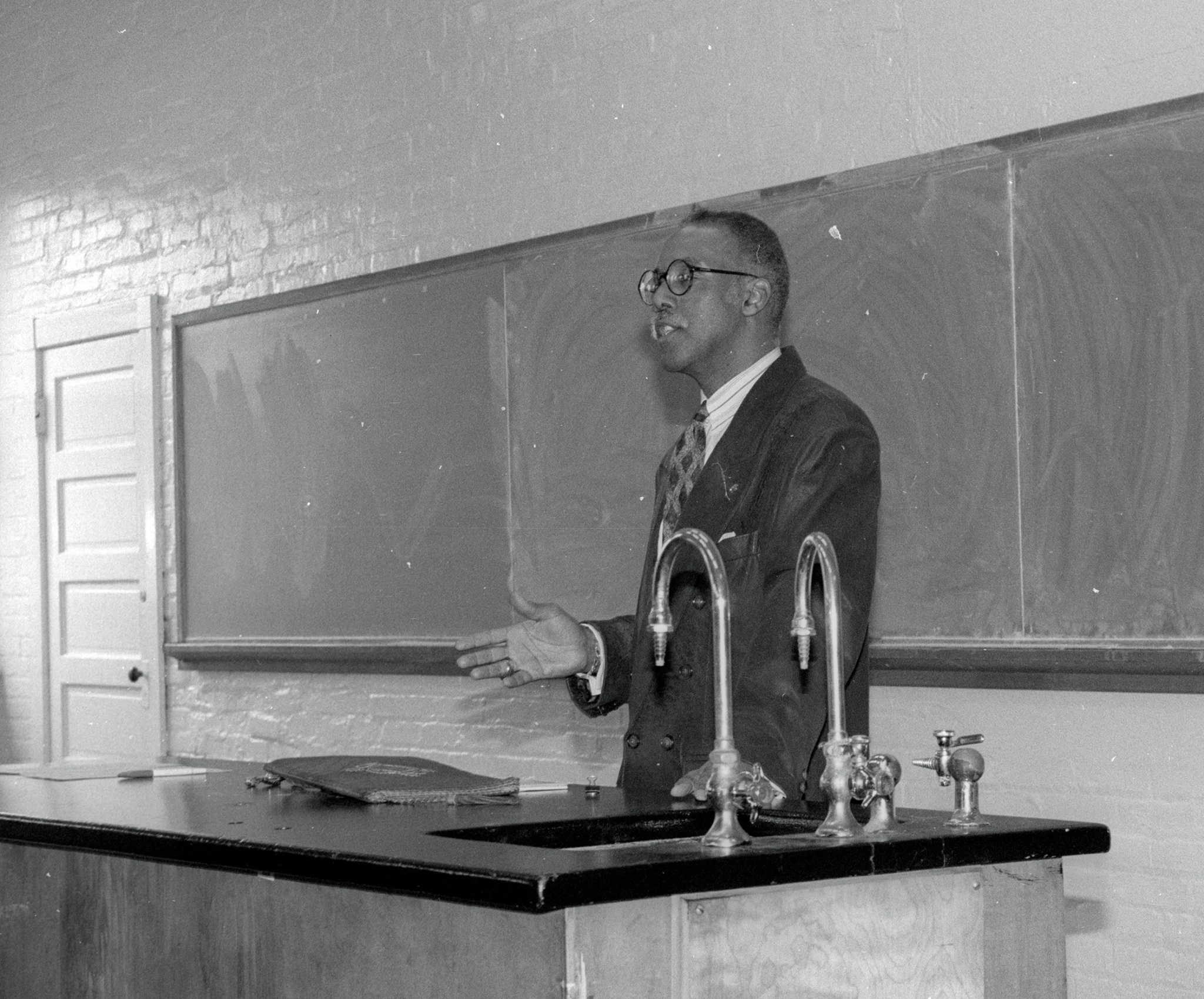 Man talking in front of blackboard.