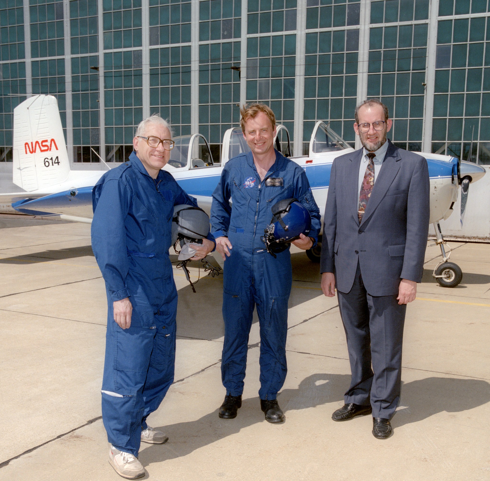 Three men standing beside small aircraft.