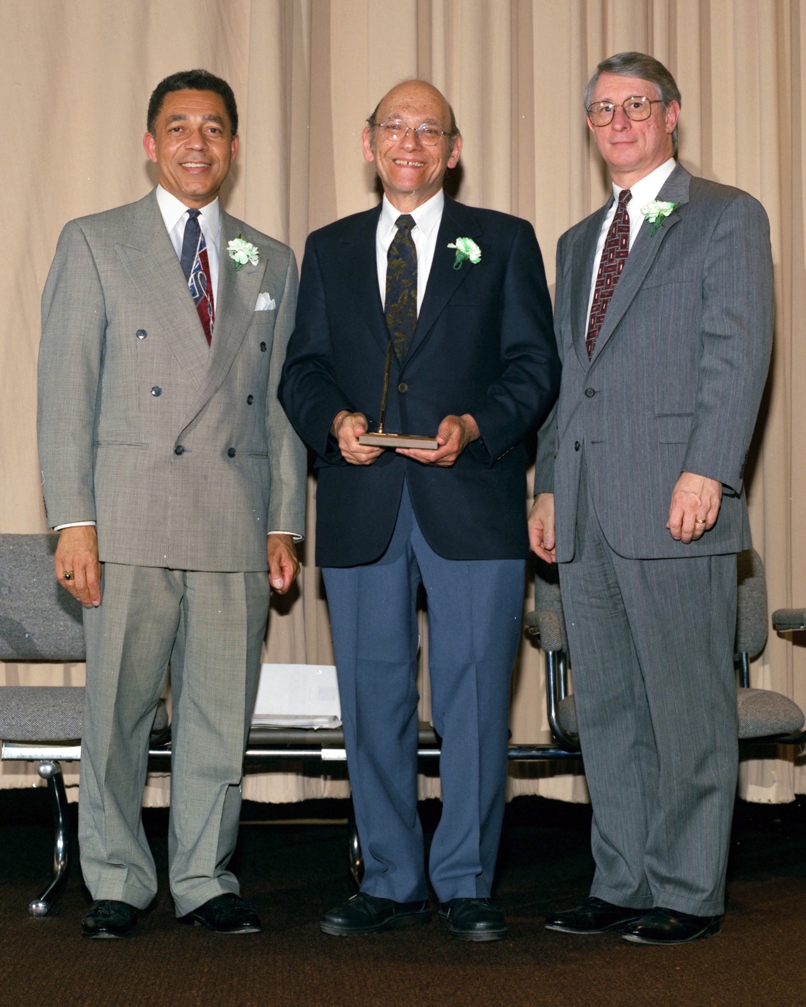 Three men standing on stage.