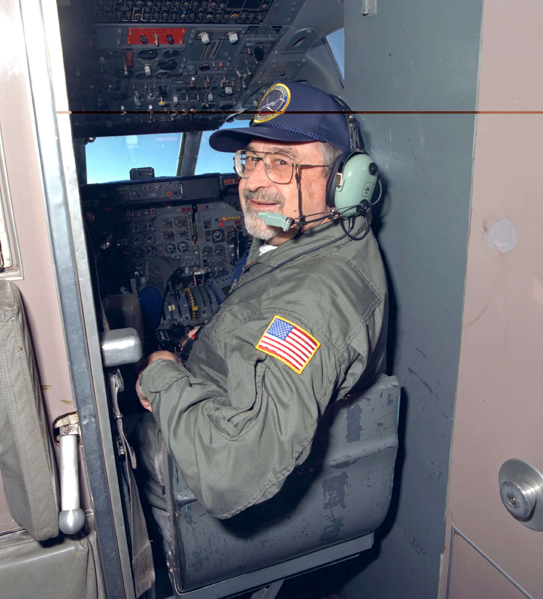 Man looking rearward from cockpit.