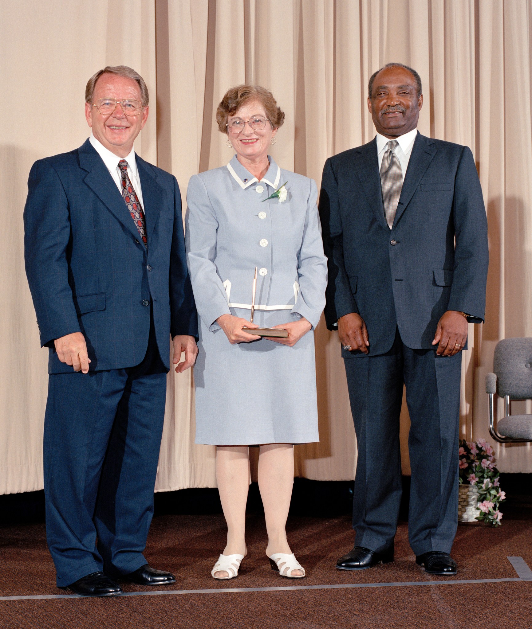 Woman standing between two men.