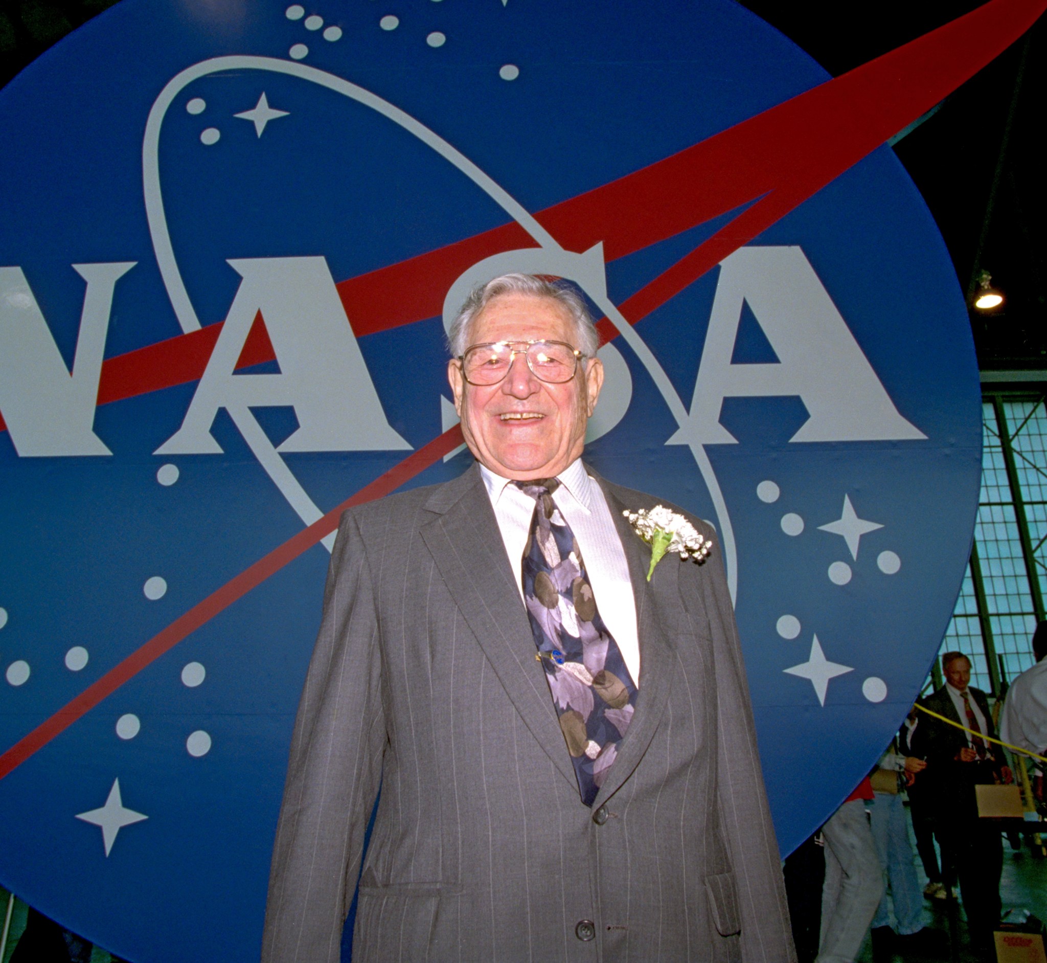 Man standing in front of NASA insignia.