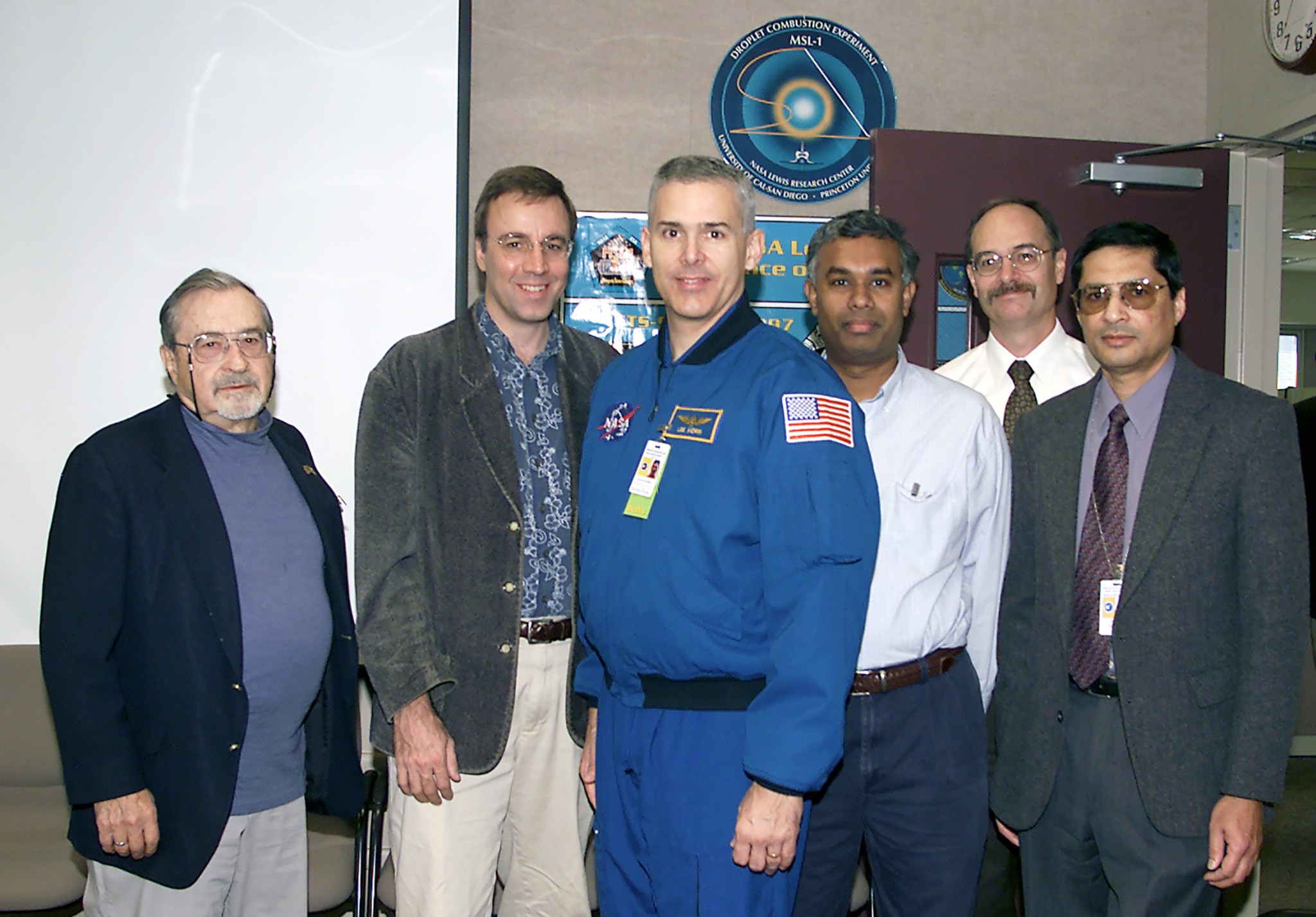 Group of people standing with astronaut.