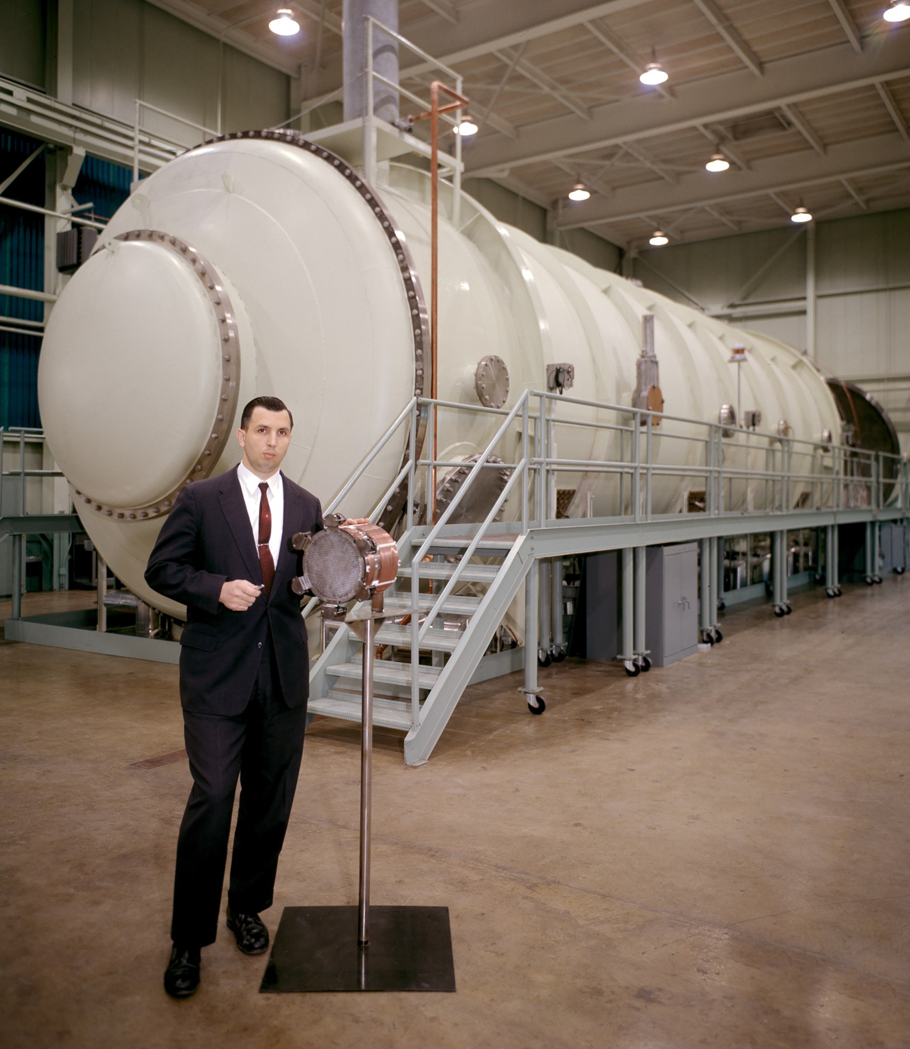 Man staning in front of vacuum chamber.