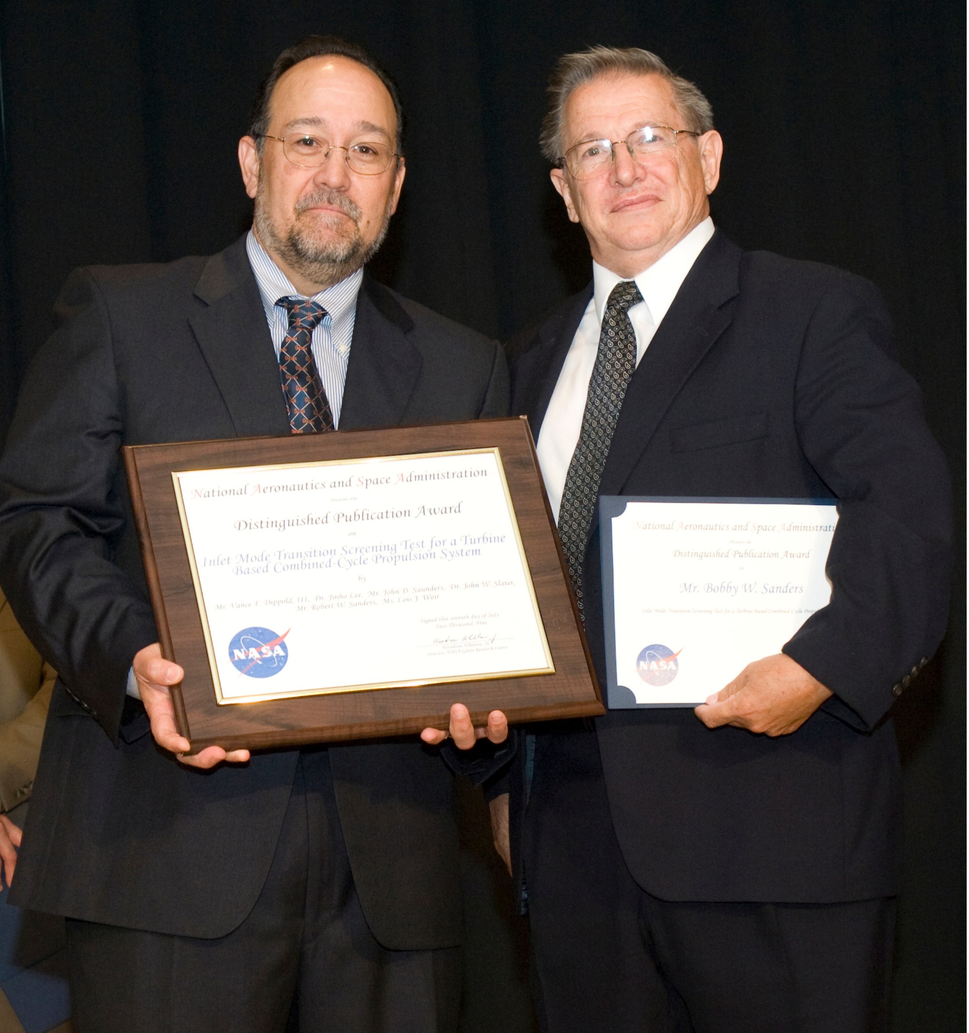 Two men holding plaques.