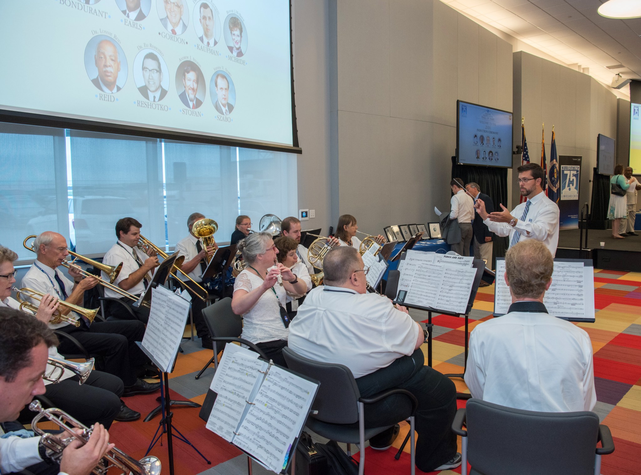 Seated band playing in auditorium.