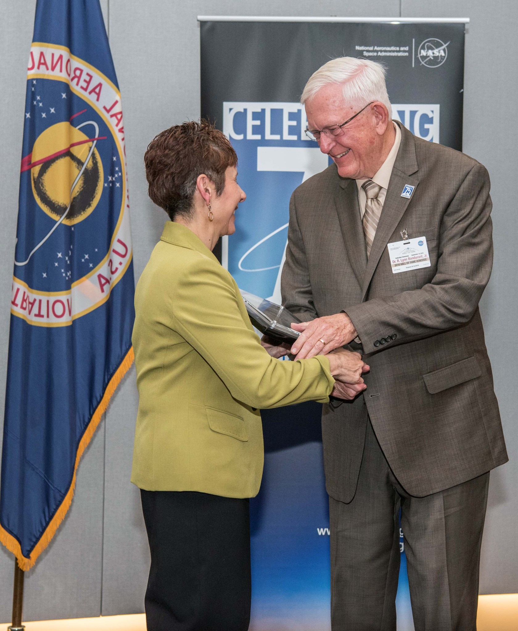 Woman presenting award to man.