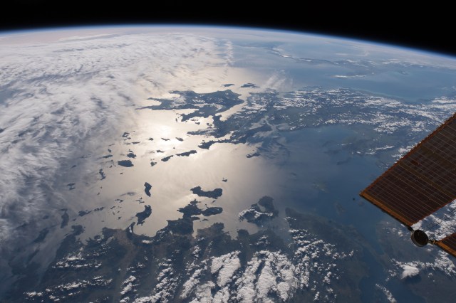 This view from above the nation of Turkey looks out across the Aegean Sea, over Greece and onto the Ionian Sea where Sicily and the boot of Italy are barely visible. The sun's glint on the Mediterranean waters highlight the Greek islands while clouds cloak the island of Crete.