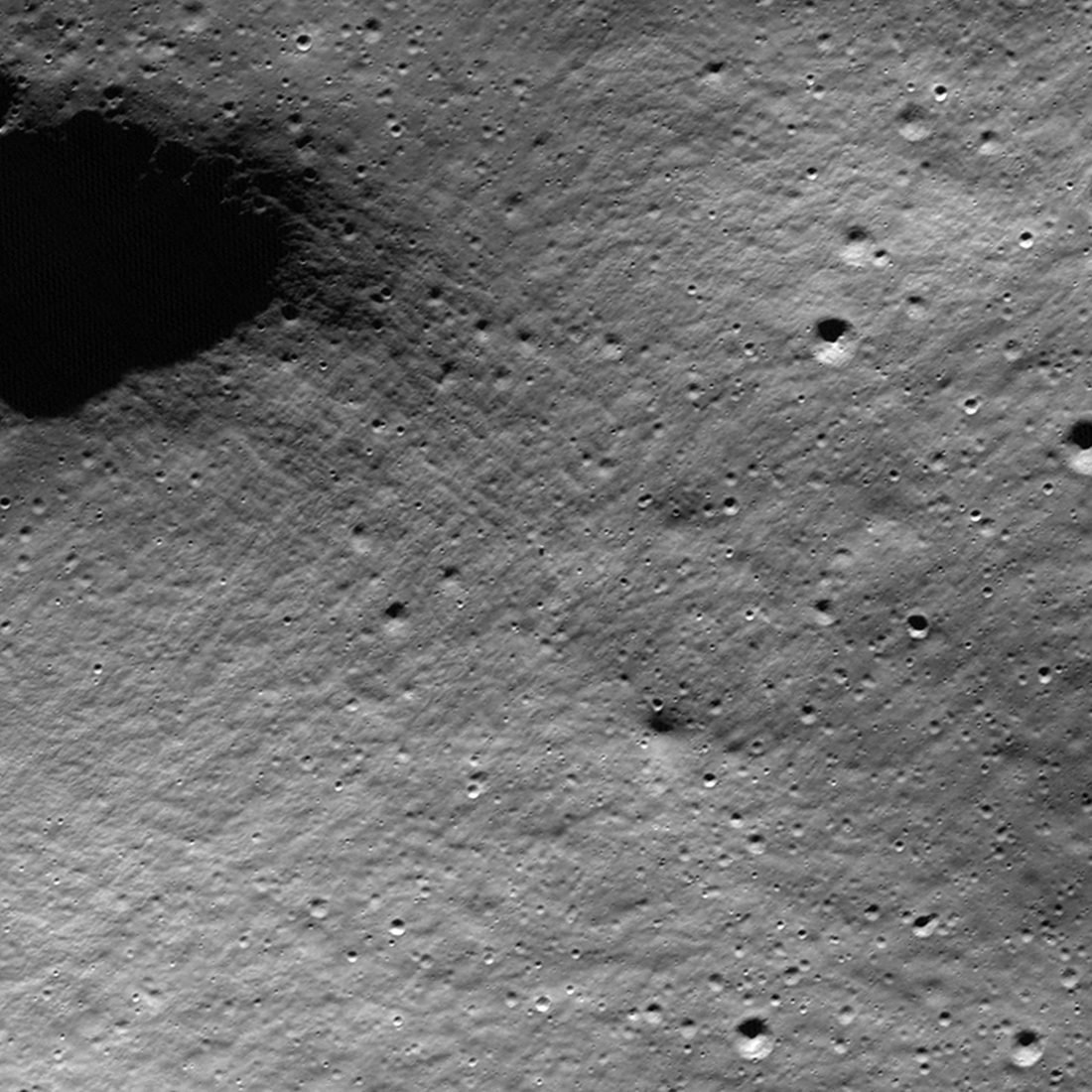 animation of two grayscale images (before and after) of Moon's rocky surface from above, with a small white dot at the center of the frame: IM-1 lander