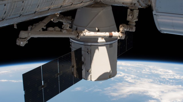 The SpaceX Dragon resupply ship, held firmly in the grip of the Canadarm2 robotic arm, is pictured shortly after it was installed to the Harmony module's Earth-facing port.