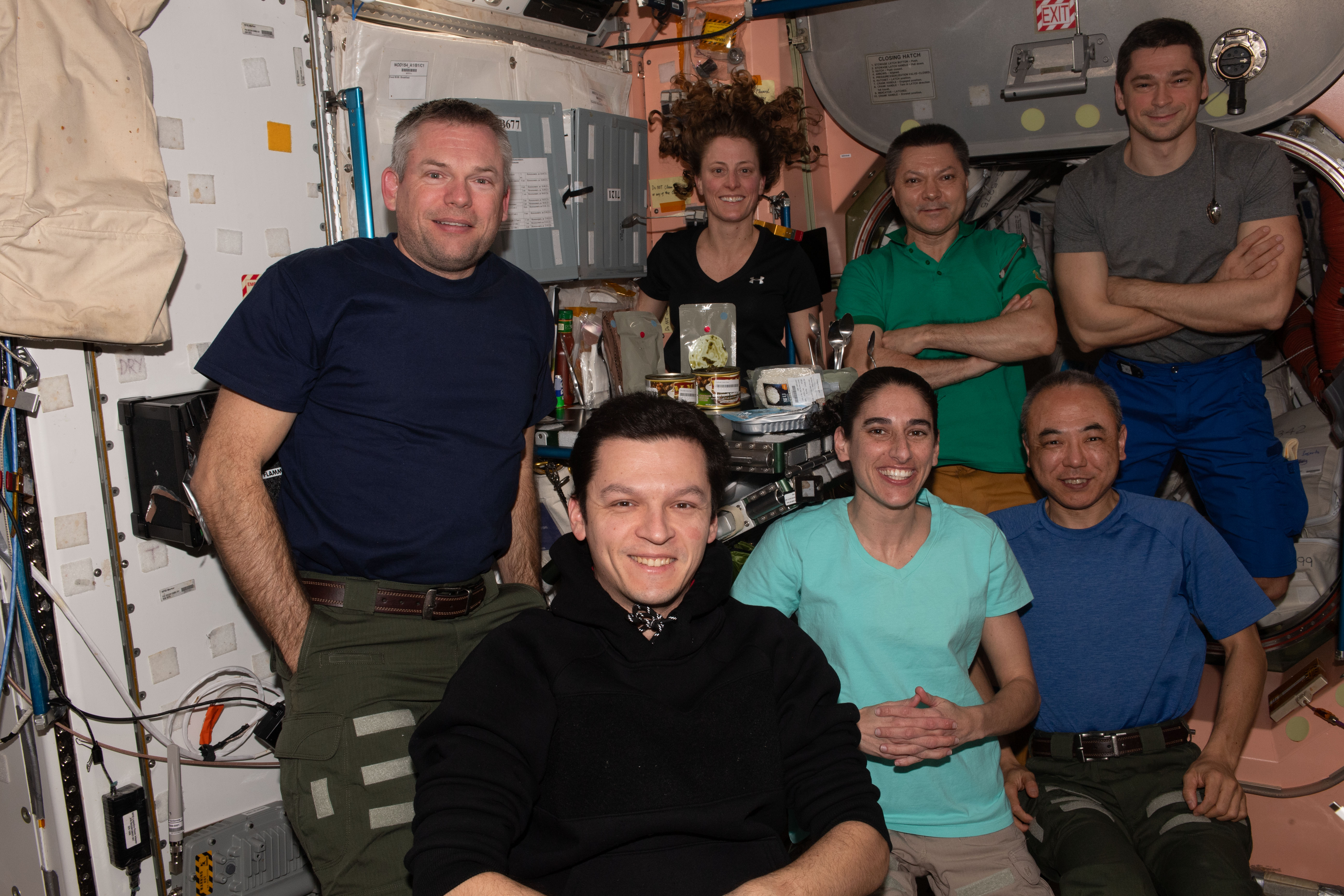 The seven-member Expedition 70 crew gathers for a dinner time portrait inside the International Space Station's Unity module. In the front row from left are, Flight Engineers Konstantin Borisov of Roscosmos, Jasmin Moghbeli of NASA, and Satoshi Furukawa from JAXA (Japan Aerospace Exploration Agency). In the back row are, Commander Andreas Mogensen from ESA (European Space Agency), NASA Flight Engineer Loral O'Hara, and Roscosmos Flight Engineers Oleg Kononenko and Nikolai Chub.
