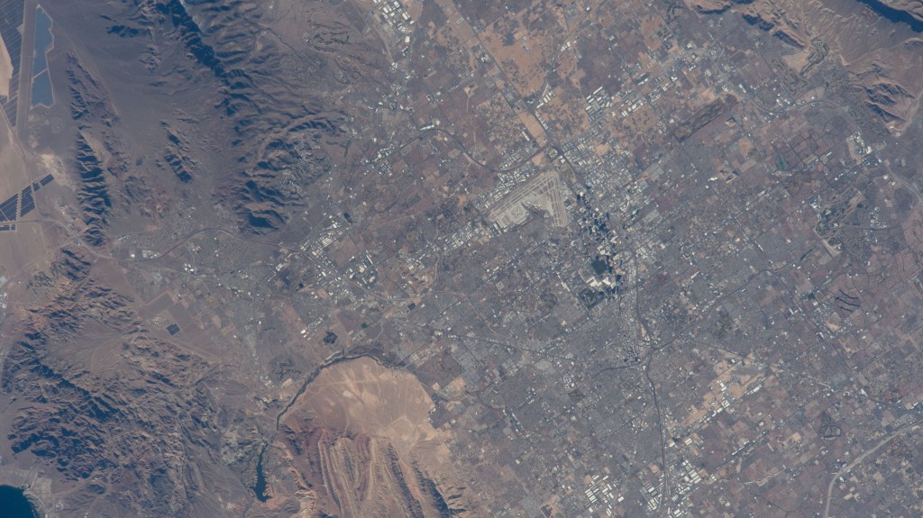 The International Space Station was soaring 261 miles above Las Vegas at the time of this photograph minutes before kickoff at Super Bowl LVIII on Feb. 11, 2024. Landmarks pictured from an external station camera are, Allegiant Stadium, The Sphere (partially obscured by shadow), and Harry Reid International Airport.