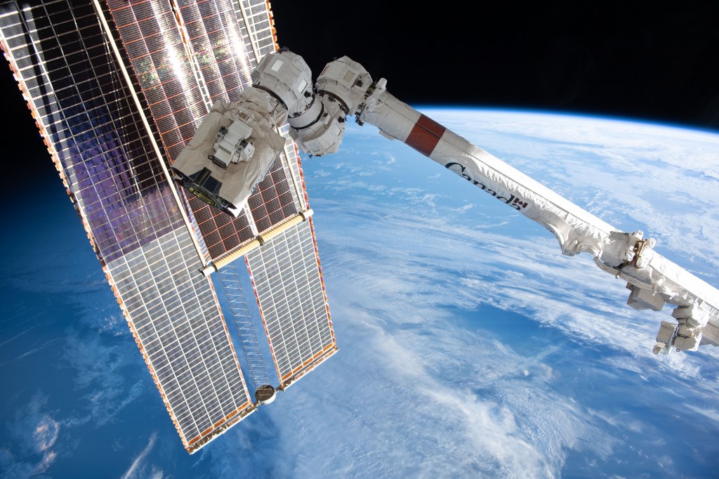 A set of the International Space Station's main solar arrays, a pair of smaller rollout solar arrays, and the Canadarm2 robotic arm with the latching end eeffector on its tip, are pictured as the orbital complex soared 263 miles above the Atlantic Ocean near the coast of Ireland.