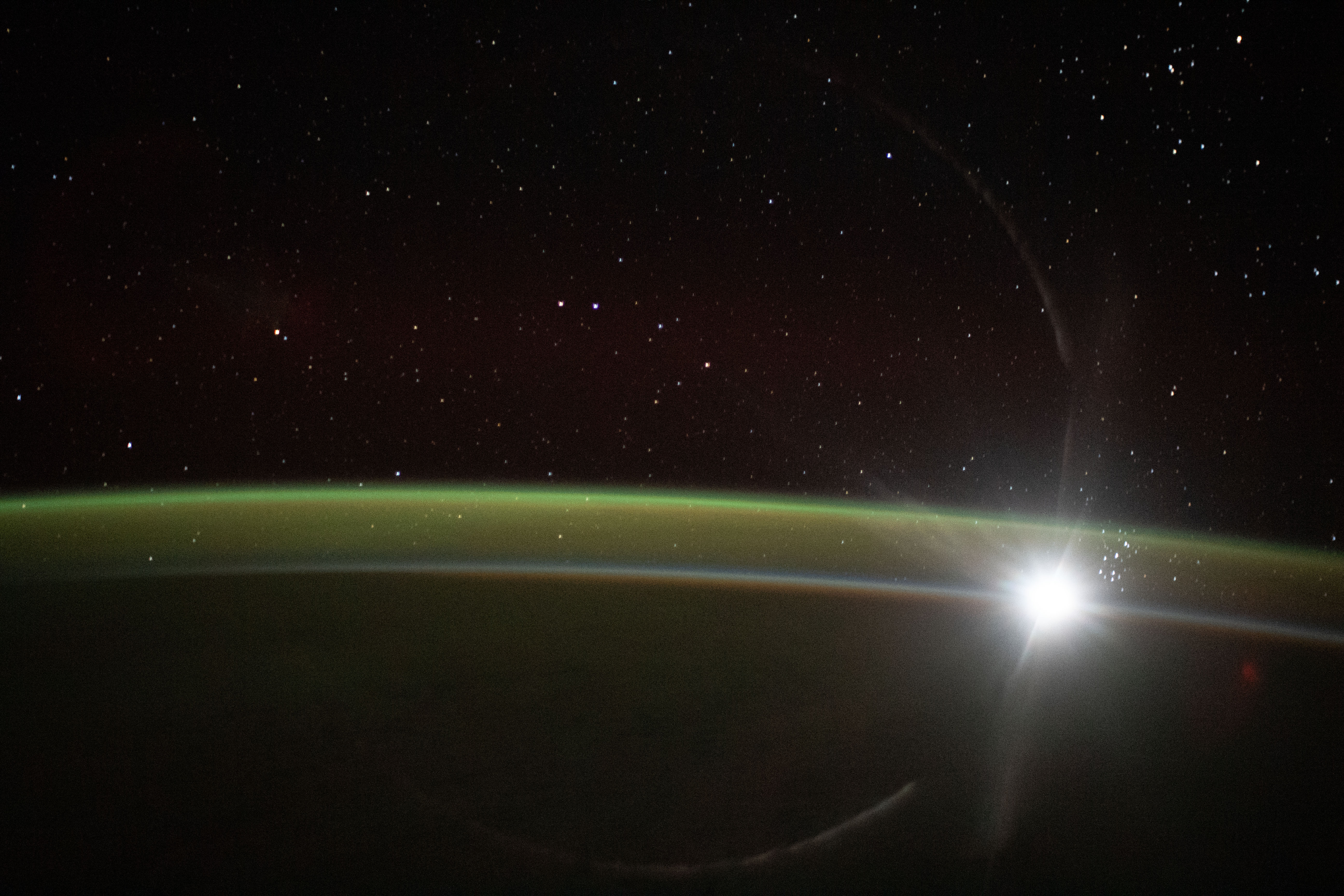 The fading light of an orbital sunset barely illuminates Earth's horizon and reveals an atmospheric glow as the International Space Station soared 267 miles above the Indian Ocean southwest of Australia.