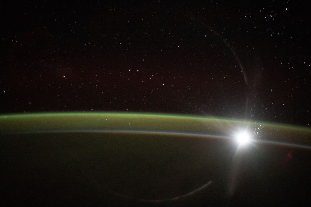 The fading light of an orbital sunset barely illuminates Earth's horizon and reveals an atmospheric glow as the International Space Station soared 267 miles above the Indian Ocean southwest of Australia.