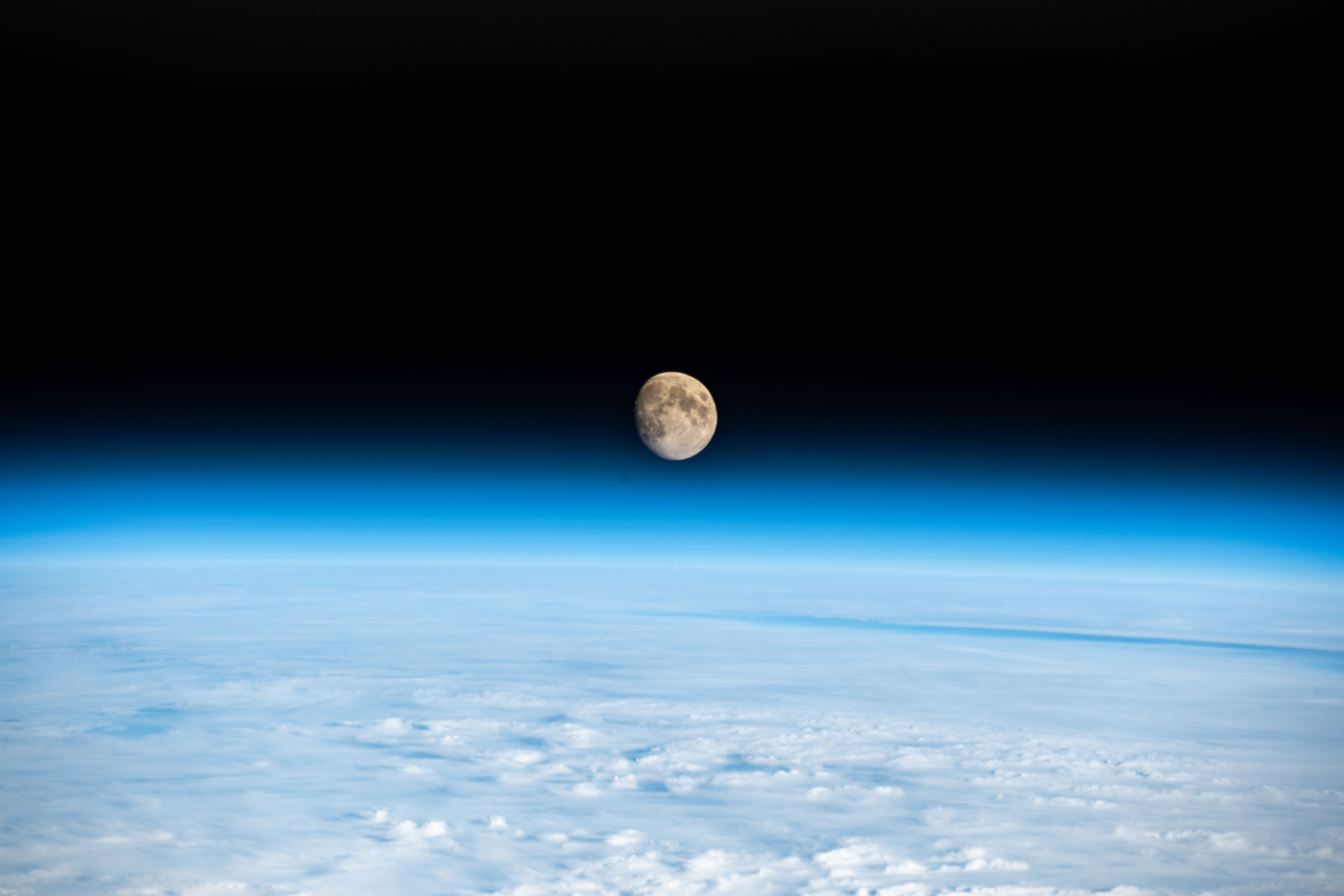 The waxing gibbous Moon is pictured above the Earth's horizon in this photograph from the International Space Station as it orbited 262 miles above a cloudy Western Europe.