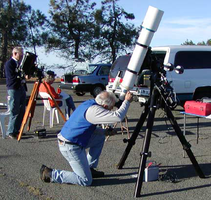2 men with telescopes looking at eclipse