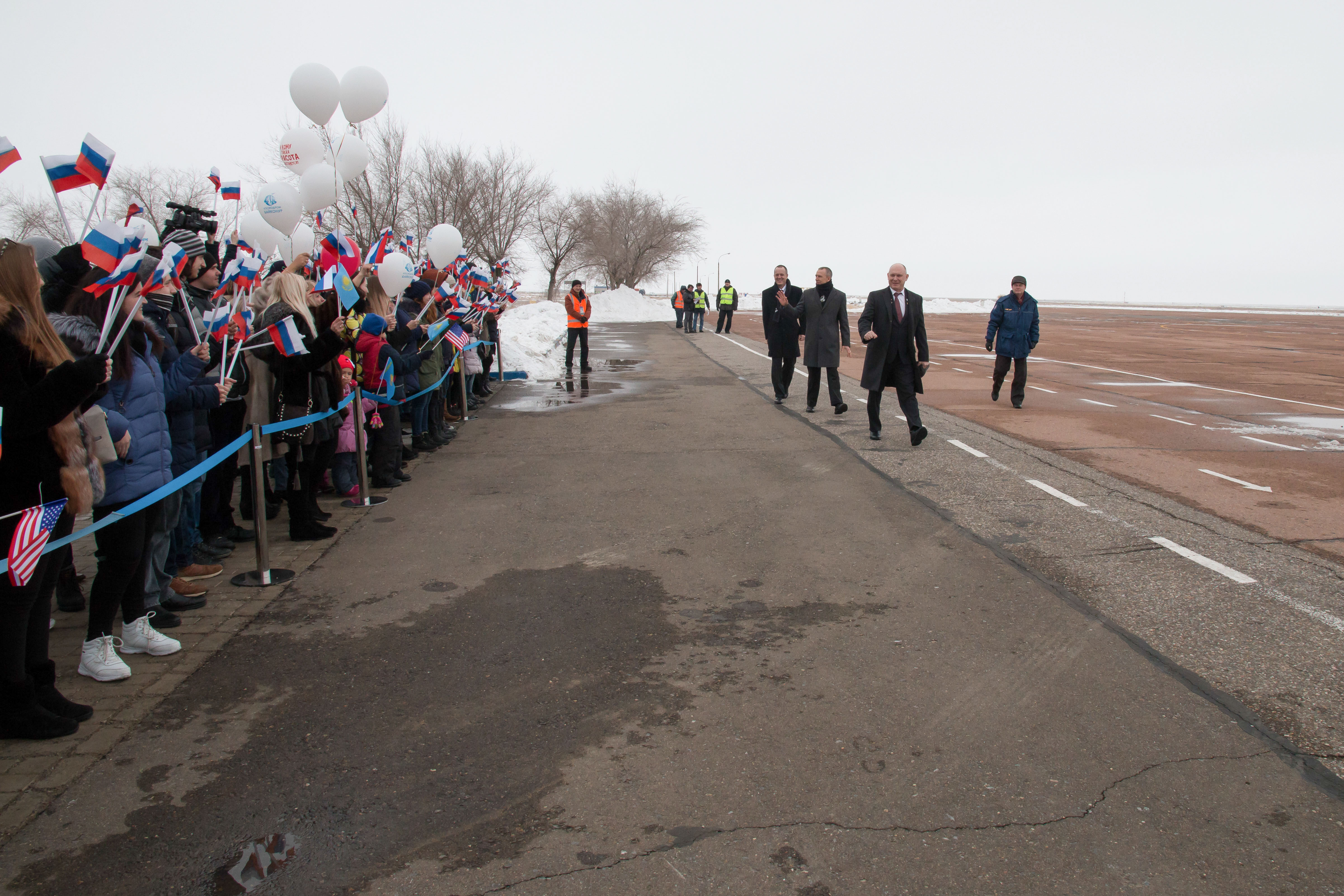 Expedition 55 crewmembers Ricky Arnold of NASA, Oleg Artemyev of Roscosmos and Drew Feustel of NASA are greeted by local school children in Baikonur, Kazakhstan after their arrival March 4 following a flight from their training base outside of Moscow. The trio will launch March 21 on the Soyuz MS-08 spacecraft for a five month mission on the International Space Station.
