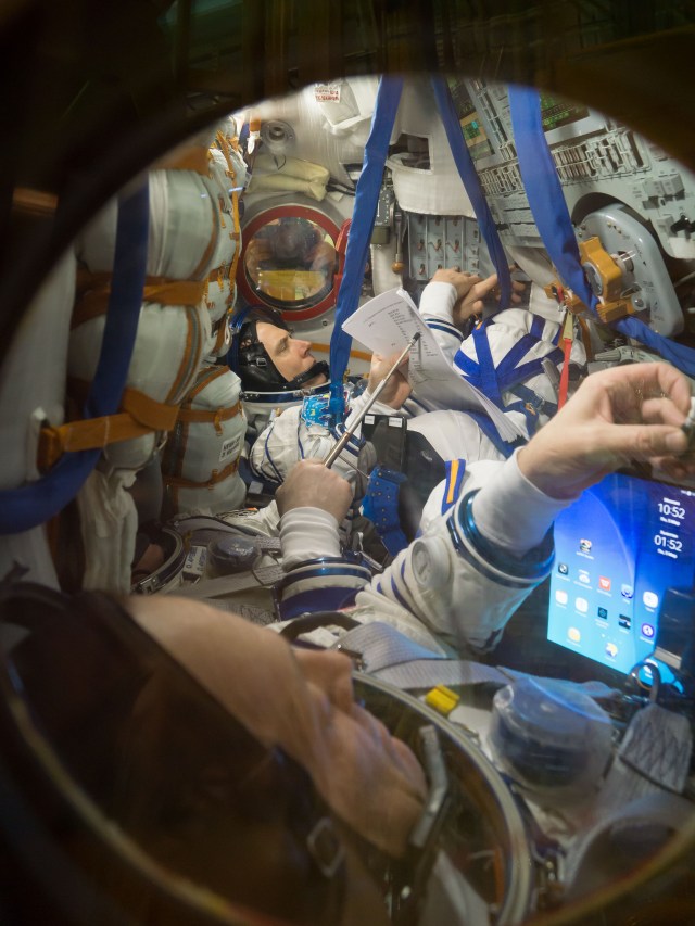 At the Baikonur Cosmodrome in Kazakhstan, Expedition 55 crew members Drew Feustel of NASA (top) and Ricky Arnold of NASA (foreground) review procedures March 5 inside their Soyuz spacecraft as part of the crew’s first vehicle fit check activities. Partially obscured in the center seat is crewmate Oleg Artemyev of Roscosmos. They will launch March 21 in the Soyuz MS-08 spacecraft from Baikonur for a five-month mission on the International Space Station.