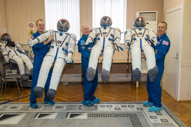 At the Baikonur Cosmodrome in Kazakhstan, Expedition 55 crewmembers Ricky Arnold of NASA (left), Oleg Artemyev of Roscosmos (center) and Drew Feustel of NASA (right) pose for pictures with their Russian Sokol launch and entry suits March 5 as part of the crew’s first vehicle fit check activities. They will launch March 21 in the Soyuz MS-08 spacecraft from Baikonur for a five-month mission on the International Space Station.