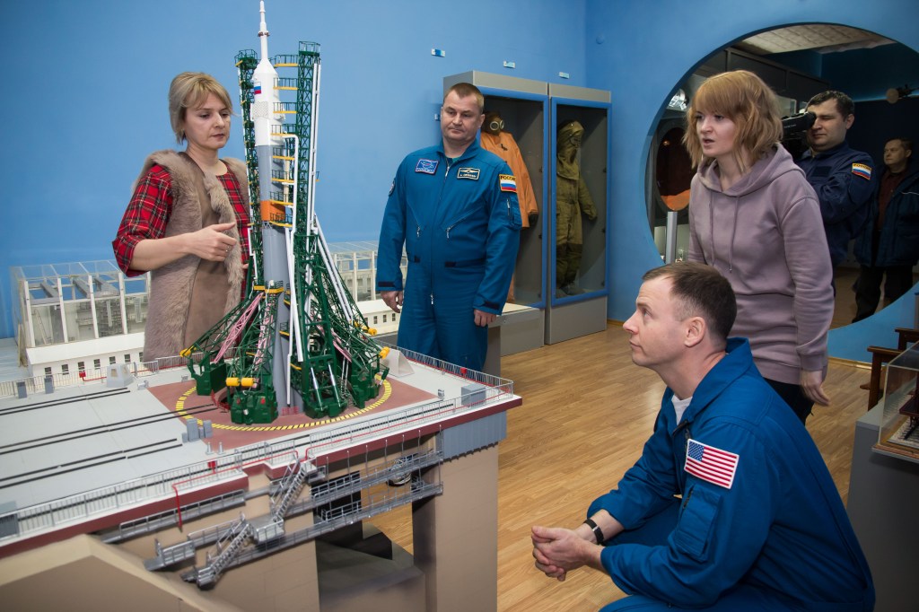 In the city of Baikonur, Kazakhstan, Expedition 55 backup crewmembers Alexey Ovchinin of Roscosmos (second from left) and Nick Hague of NASA (crouching) receive a briefing on the elements of a Soyuz rocket model March 6 during a traditional tour of the city’s museum. Prime crewmembers Drew Feustel and Ricky Arnold of NASA and Oleg Artemyev of Roscosmos will launch March 21 on the Soyuz MS-08 spacecraft from the Baikonur Cosmodrome for a five-month mission on the International Space Station.