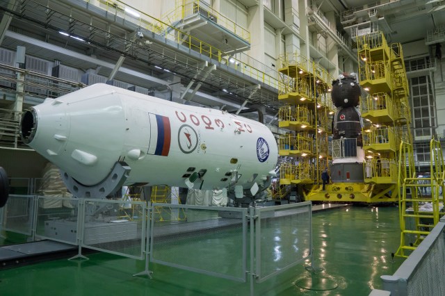 In the Integration Facility at the Baikonur Cosmodrome in Kazakhstan, the Soyuz MS-08 spacecraft (right) awaits its rotation to a horizontal position March 14 to be encapsulated in the upper stage of a Soyuz booster rocket (left). Expedition 55 crewmembers Drew Feustel and Ricky Arnold of NASA and Oleg Artemyev of Roscosmos will launch in the Soyuz March 21 for a five-month mission on the International Space Station.