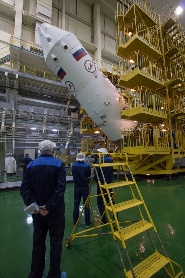 In the Integration Facility at the Baikonur Cosmodrome in Kazakhstan, engineers look on as the upper stage of a Soyuz booster rocket is raised to a vertical position March 14 after the Soyuz MS-08 spacecraft was encapsulated into the booster. Expedition 55 crewmembers Drew Feustel and Ricky Arnold of NASA and Oleg Artemyev of Roscosmos will launch in the Soyuz March 21 for a five-month mission on the International Space Station.