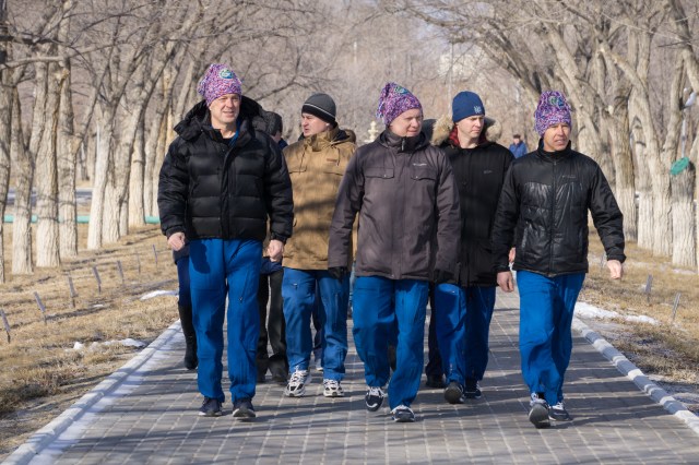 At the Cosmonaut Hotel crew quarters in Baikonur, Kazakhstan, Expedition 55 crewmembers Ricky Arnold of NASA (left), Oleg Artemyev of Roscosmos (center) and Drew Feustel of NASA (right) take a stroll down the Walk of Cosmonauts March 15 as part of their pre-launch activities. They will launch March 21 on the Soyuz MS-08 spacecraft from the Baikonur Cosmodrome on a five-month mission to the International Space Station.
