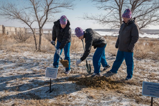 At the Cosmonaut Hotel crew quarters in Baikonur, Kazakhstan, Expedition 55 crew member Drew Feustel of NASA (center) plants a tree in his name in traditional pre-launch activities March 15. Assisting Feustel is Ricky Arnold of NASA (left) and Oleg Artemyev of Roscosmos (right). They will launch March 21 on the Soyuz MS-08 spacecraft from the Baikonur Cosmodrome on a five-month mission to the International Space Station.
