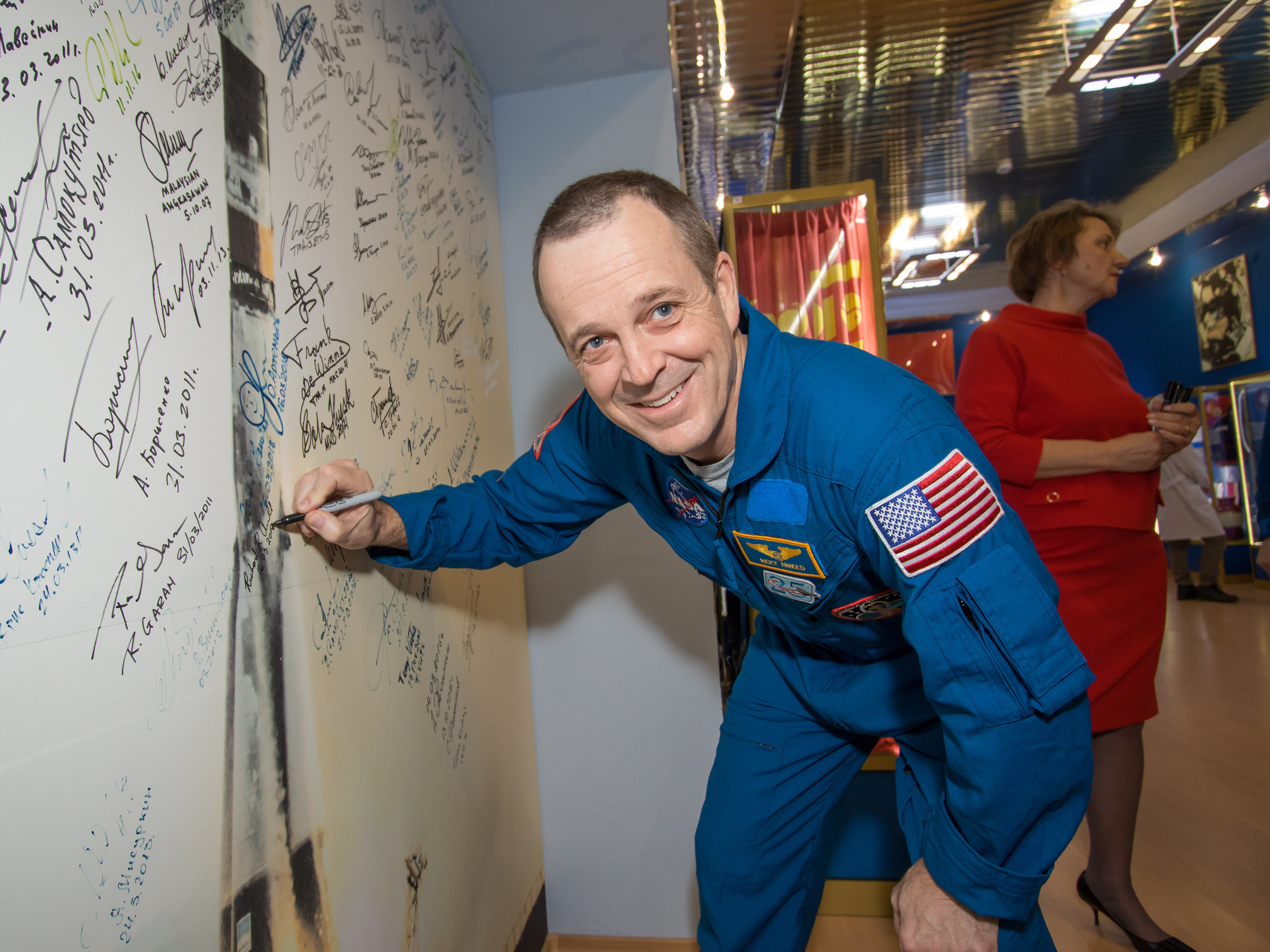 In the Korolev Museum at the Baikonur Cosmodrome in Kazakhstan, Expedition 55 crew member Ricky Arnold of NASA signs a wall mural depicting a Soyuz launch March 16 as part of traditional prelaunch activities. Arnold, Oleg Artemyev of Roscosmos and Drew Feustel of NASA will launch March 21 on the Soyuz MS-08 spacecraft for a five-month mission on the International Space Station.