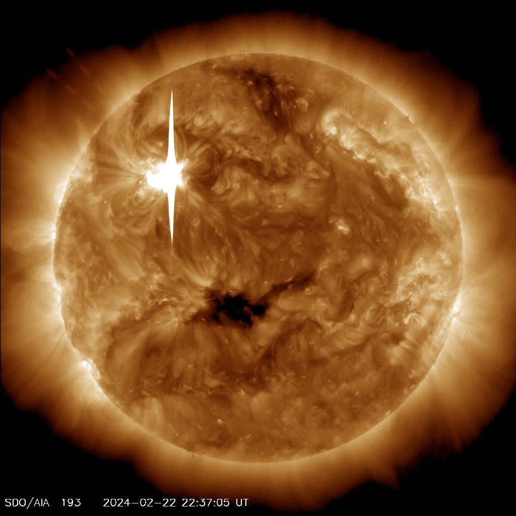 The Sun, shown in bronze. There are several bright areas and one very dark splotch. On the upper left is a bright white line – this is the flare.