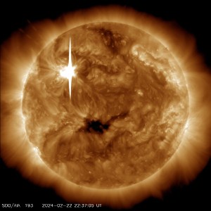 The Sun, shown in bronze. There are several bright areas and one very dark splotch. On the upper left is a bright white line – this is the flare.