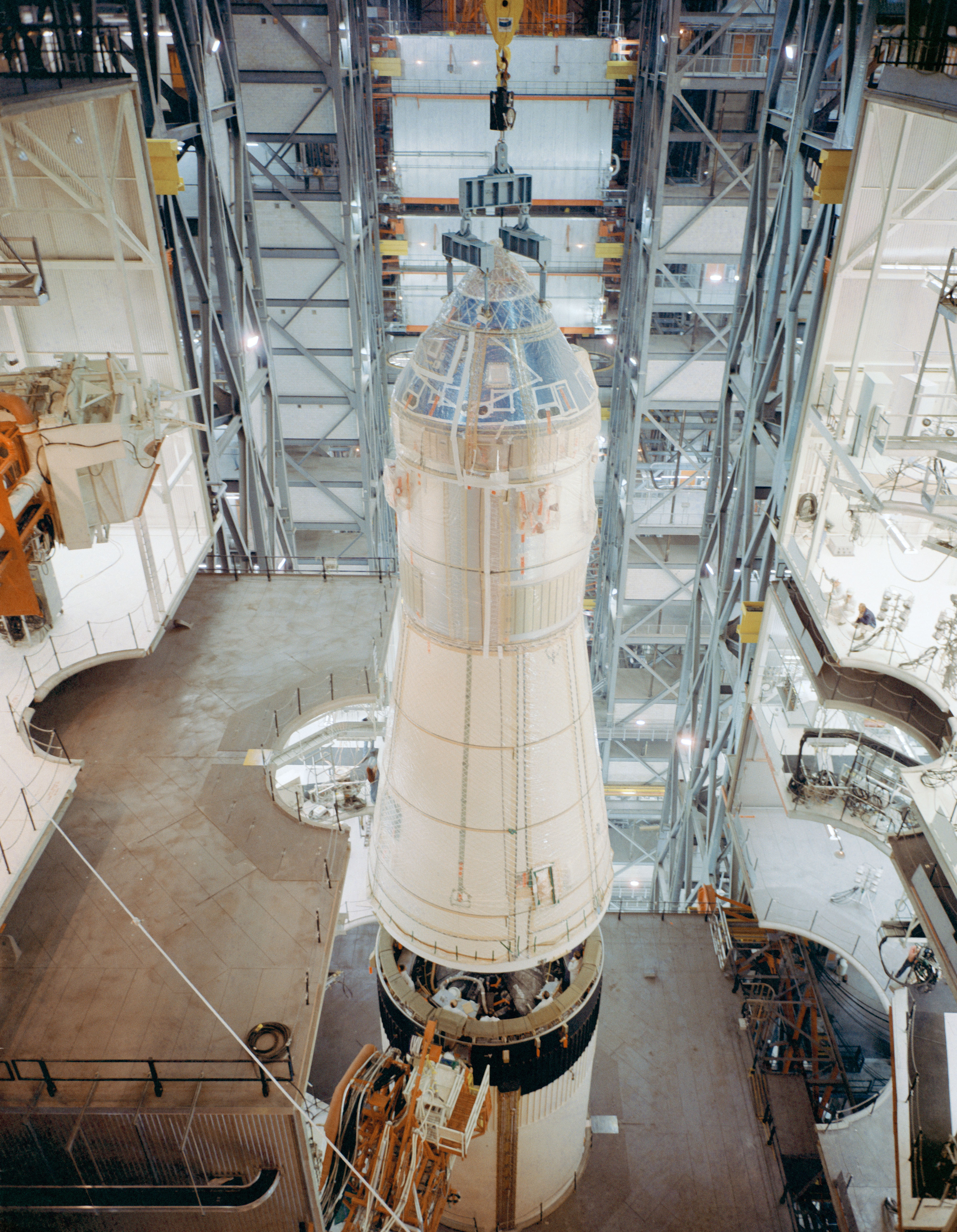 Workers lower the spacecraft onto the Saturn V rocket's third stage