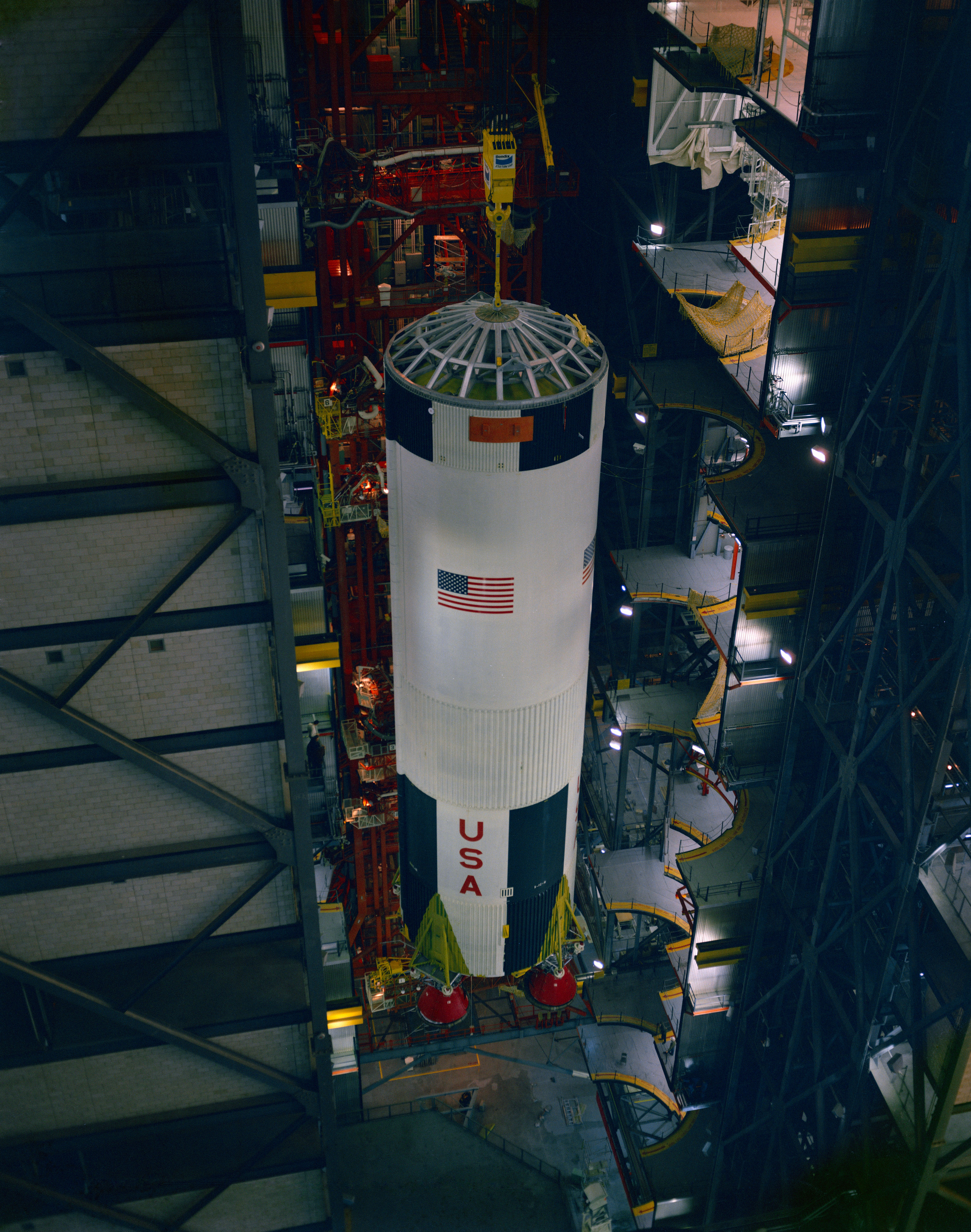 Workers mount the S-IC first stage on its Mobile Launcher in the Vehicle Assembly Building at NASA’s Kennedy Space Center in Florida