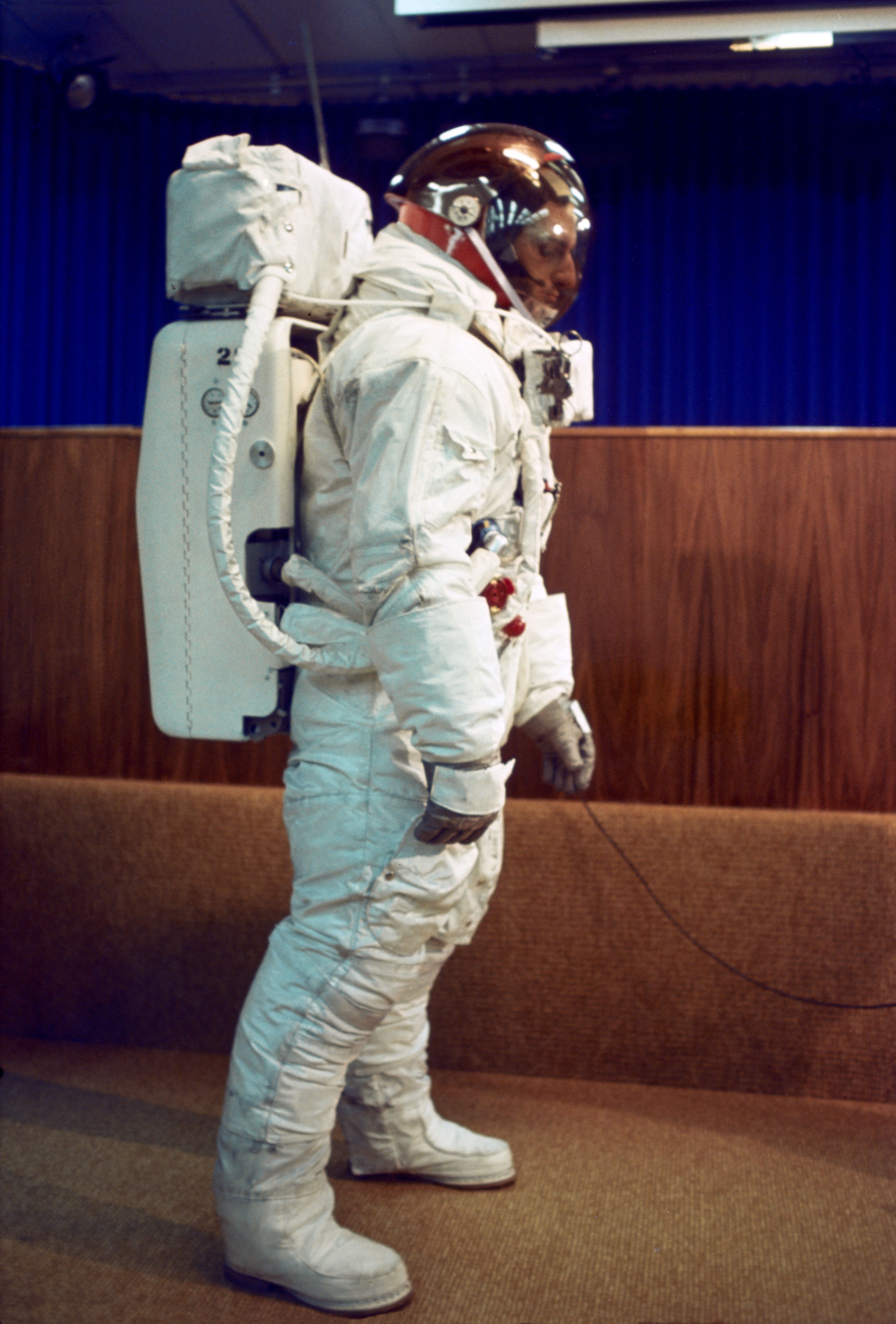 A technician poses in the Apollo A7L spacesuit, including the Portable Life Support System backpack used for the first time during Apollo 9