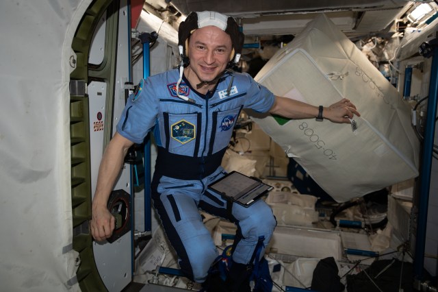 iss062e118439 (March 31, 2020) --- NASA astronaut and Expedition 62 Flight Engineer Andrew Morgan is pictured wearing a communications cap, nicknamed the "Snoopy Cap" during the Apollo era, while transferring cargo from the International Space Station into the SpaceX Dragon resupply ship.