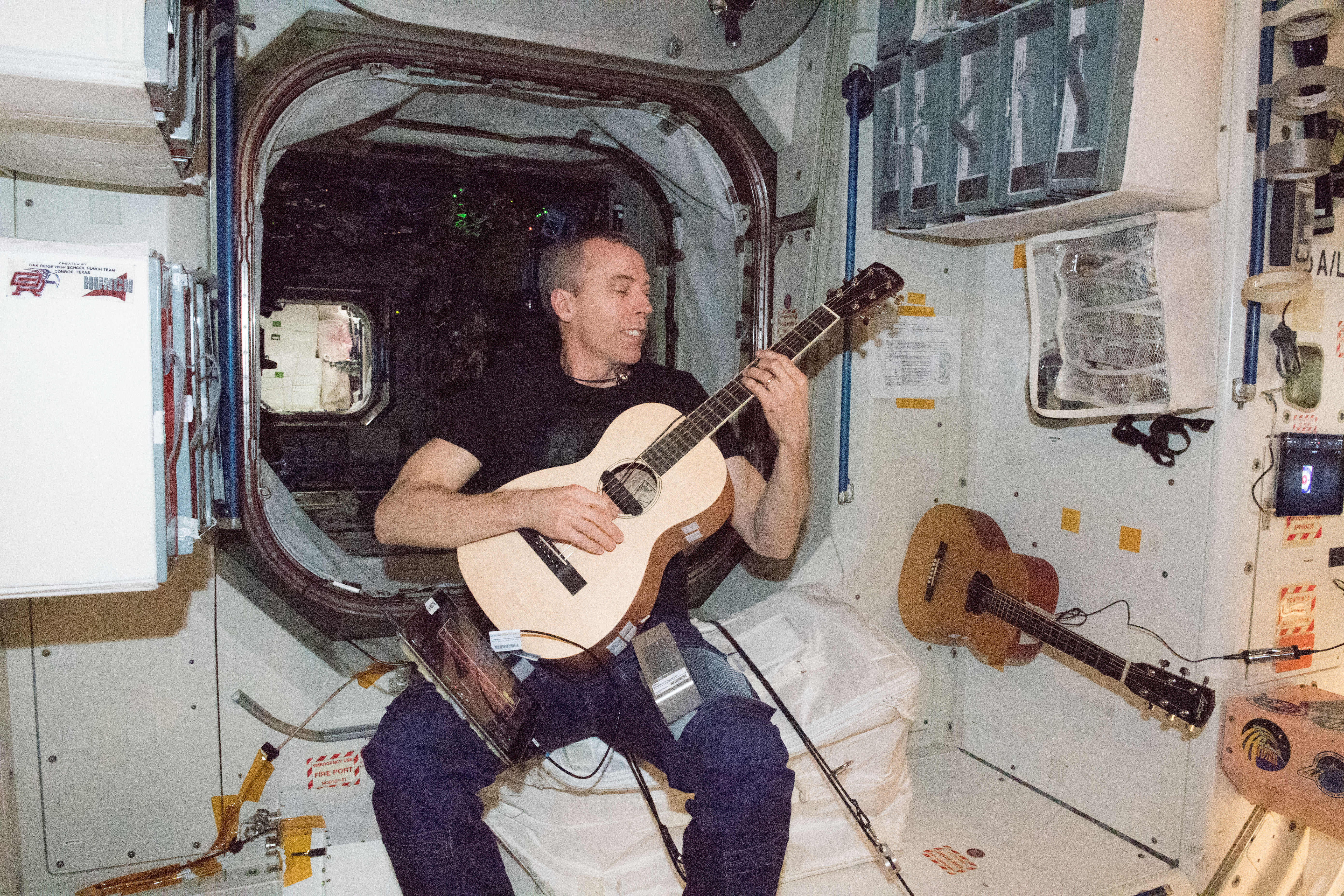 NASA astronaut Drew Feustel relaxes at the end of the workday playing guitar inside the Unity module.