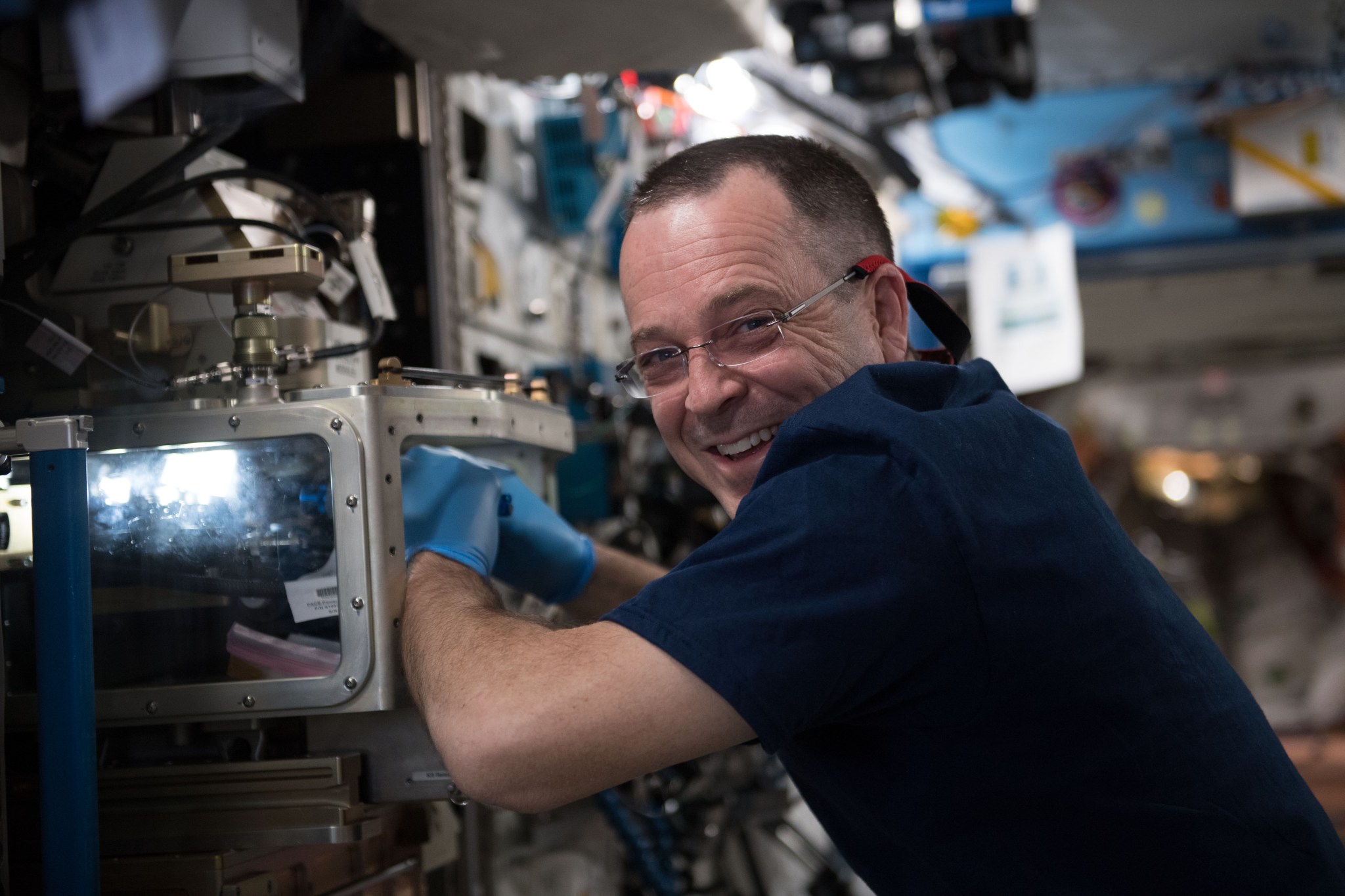 NASA astronaut Ricky Arnold performs maintenance on the Advanced Colloids Experiment Module located inside the Light Microscopy Module which is a modified commercial, highly flexible, state-of-the-art light imaging microscope facility that provides researchers with powerful diagnostic hardware and software in microgravity.