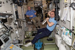 NASA astronaut Scott Tingle (background left) and Commander Anton Shkaplerov relax inside the Zvezda service module moments before the arrival of three new Expedition 55 crew members on March 23, 2018. The Soyuz MS-08 spacecraft carrying Soyuz Commander Oleg Artemyev and Flight Engineers Drew Feustel and Ricky Arnold would dock to the Poisk docking compartment on March 23, 2018 at 3:40 p.m. EDT.