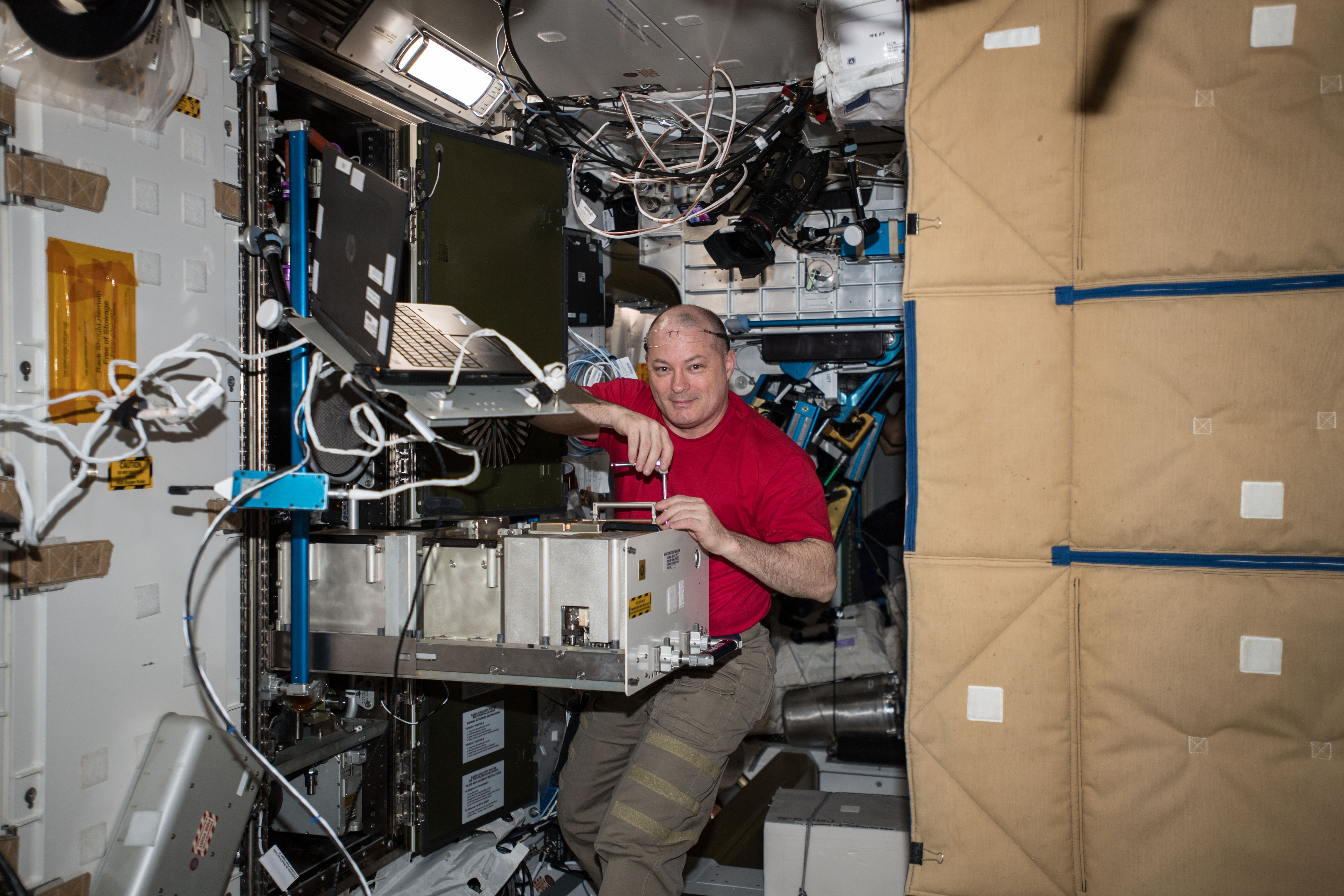 NASA astronaut Scott Tingle works inside the Tranquility module removing and replacing life support systems hardware.