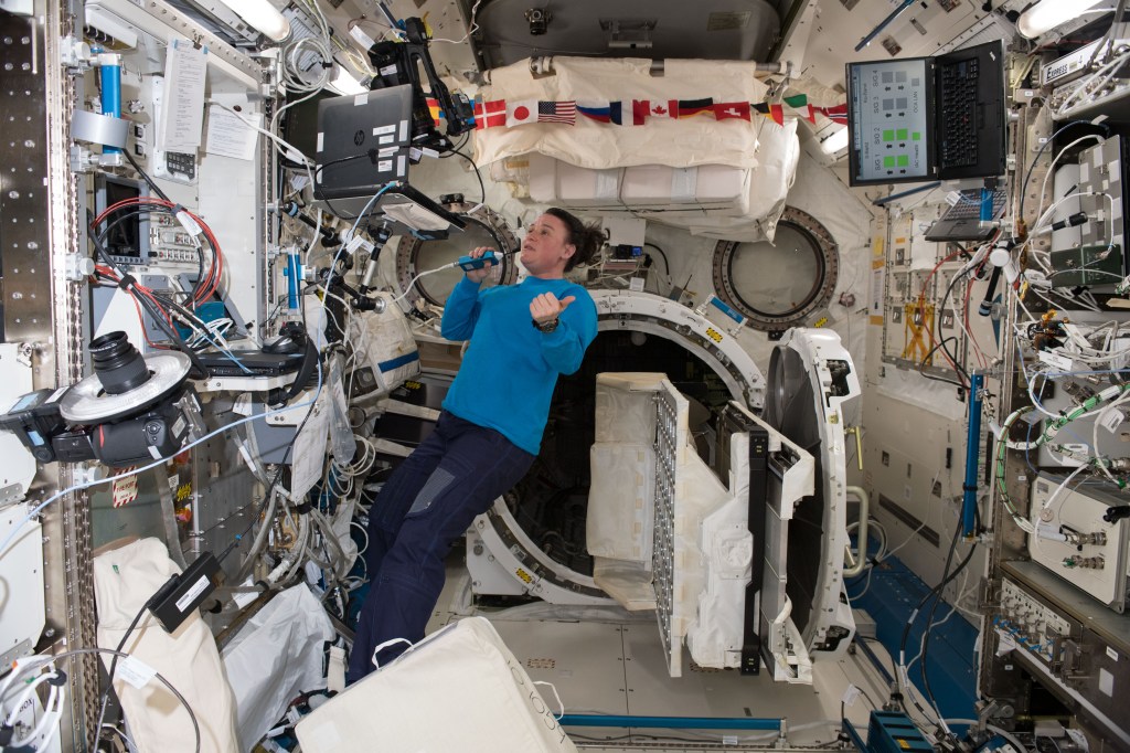 NASA astronaut Serena Auñón-Chancellor talks to mission controllers while working on life support maintenance inside the Kibo laboratory module from the Japan Aerospace Exploration Agency.