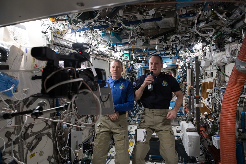 NASA astronauts (from left) Drew Feustel and Ricky Arnold record video messages for a pair of events that took place on Earth including John Glenn's memorial on April 5 and the USA Science and Engineering Festival on April 7.