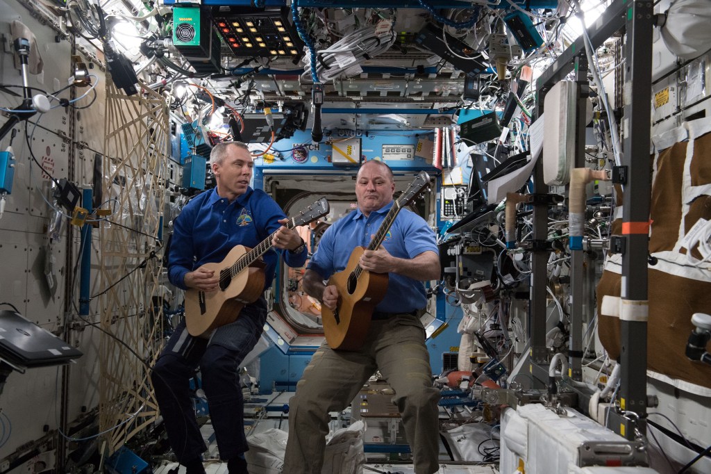 NASA astronauts Drew Feustel (left) and Scott Tingle play guitar inside the Destiny laboratory module during an educational event with school districts in Aransas Pass, Texas.