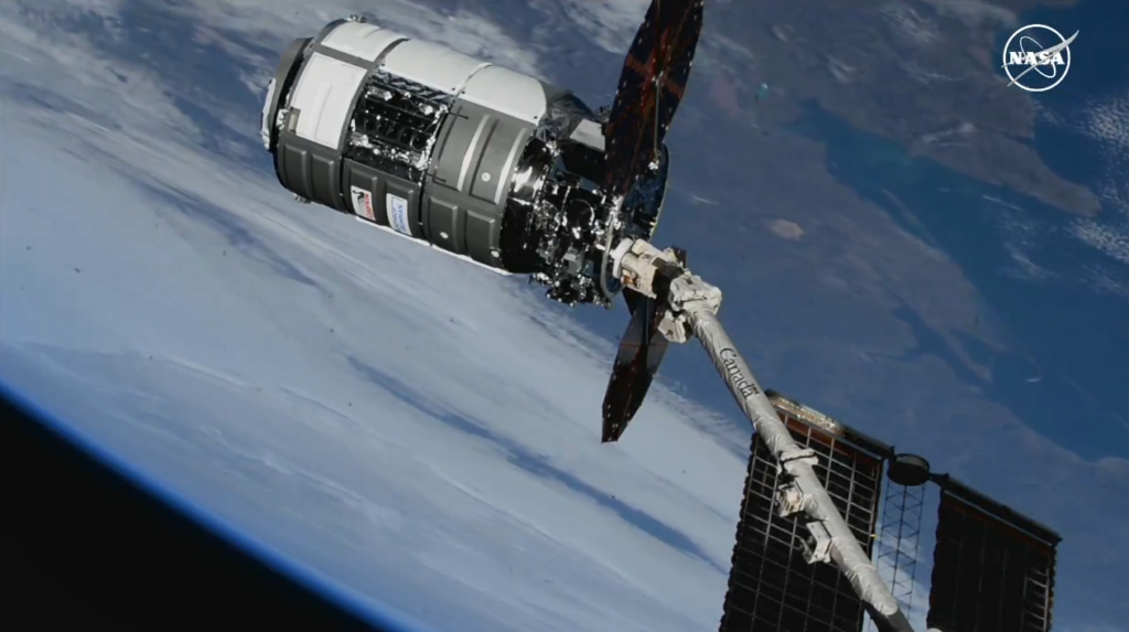 The Canadarm2 robotic arm, guided by NASA astronaut Loral O’Hara, captures Northrop Grumman’s Cygnus spacecraft. Credit: NASA TV