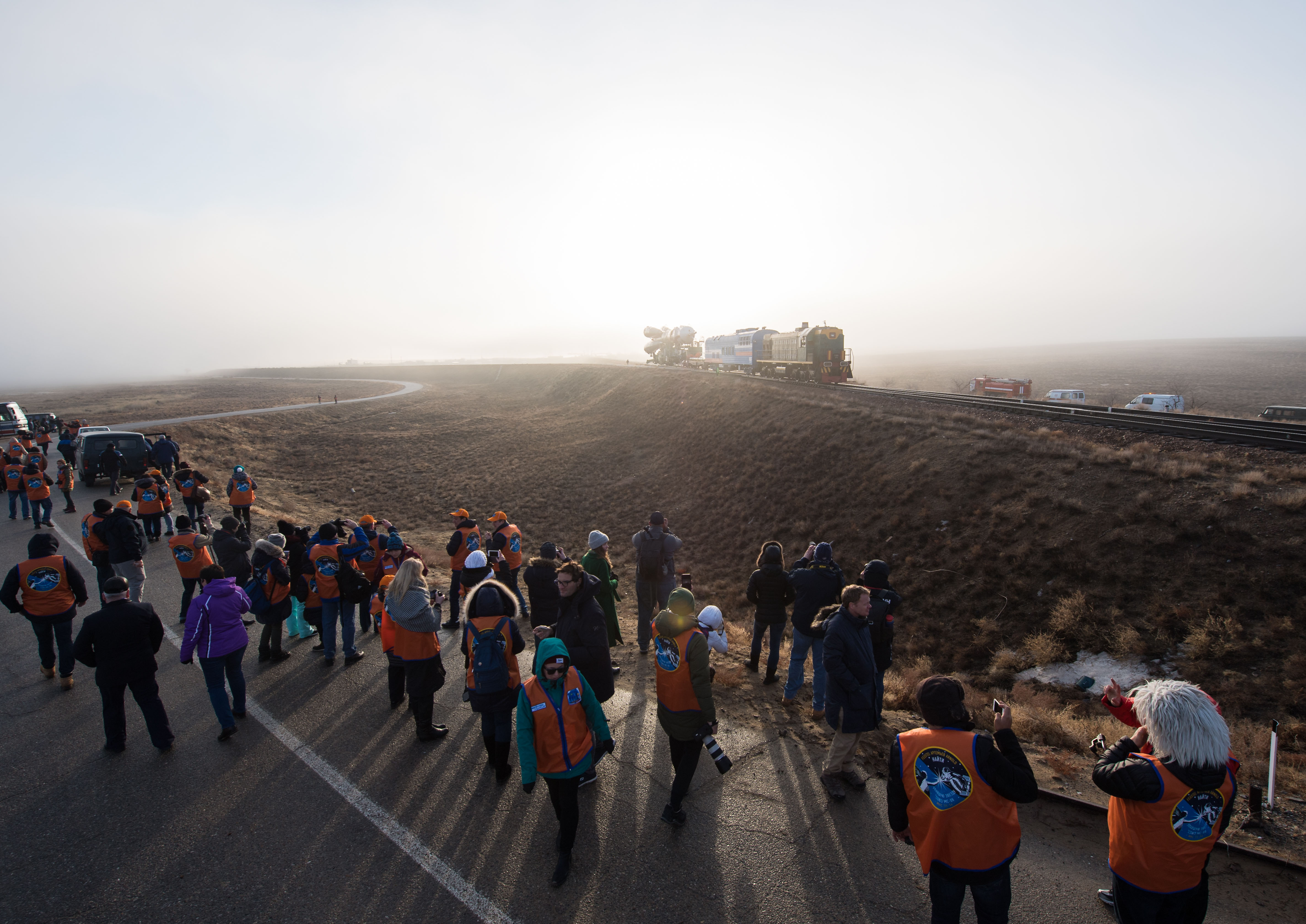 Launch guests watch as the Soyuz rocket is rolled out by train to the launch pad, Monday, March 19, 2018 at the Baikonur Cosmodrome in Kazakhstan. Expedition 55 crewmembers Ricky Arnold and Drew Feustel of NASA and Oleg Artemyev of Roscosmos are scheduled to launch at 1:44 p.m. Eastern time (11:44 p.m. Baikonur time) on March 21 and will spend the next five months living and working aboard the International Space Station.