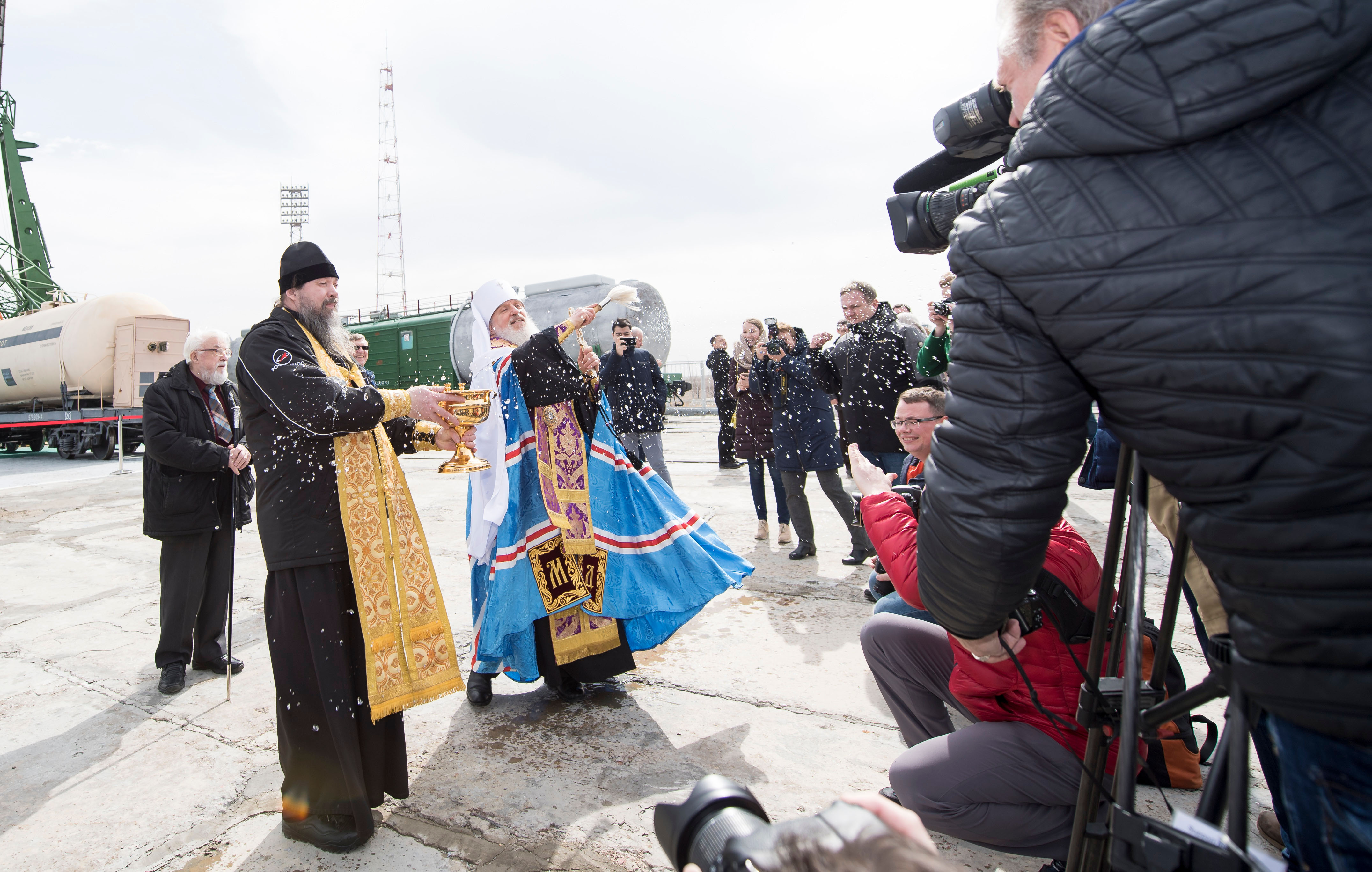 An Orthodox Priest blesses members of the media at the Baikonur Cosmodrome launch pad, Tuesday, March 20, 2018 in Baikonur, Kazahstan. Expedition 55 Soyuz Commander Oleg Artemyev of Roscosmos, Ricky Arnold and Drew Feustel of NASA are scheduled to launch to the International Space Station aboard the Soyuz MS-08 spacecraft on Wednesday, March, 21.