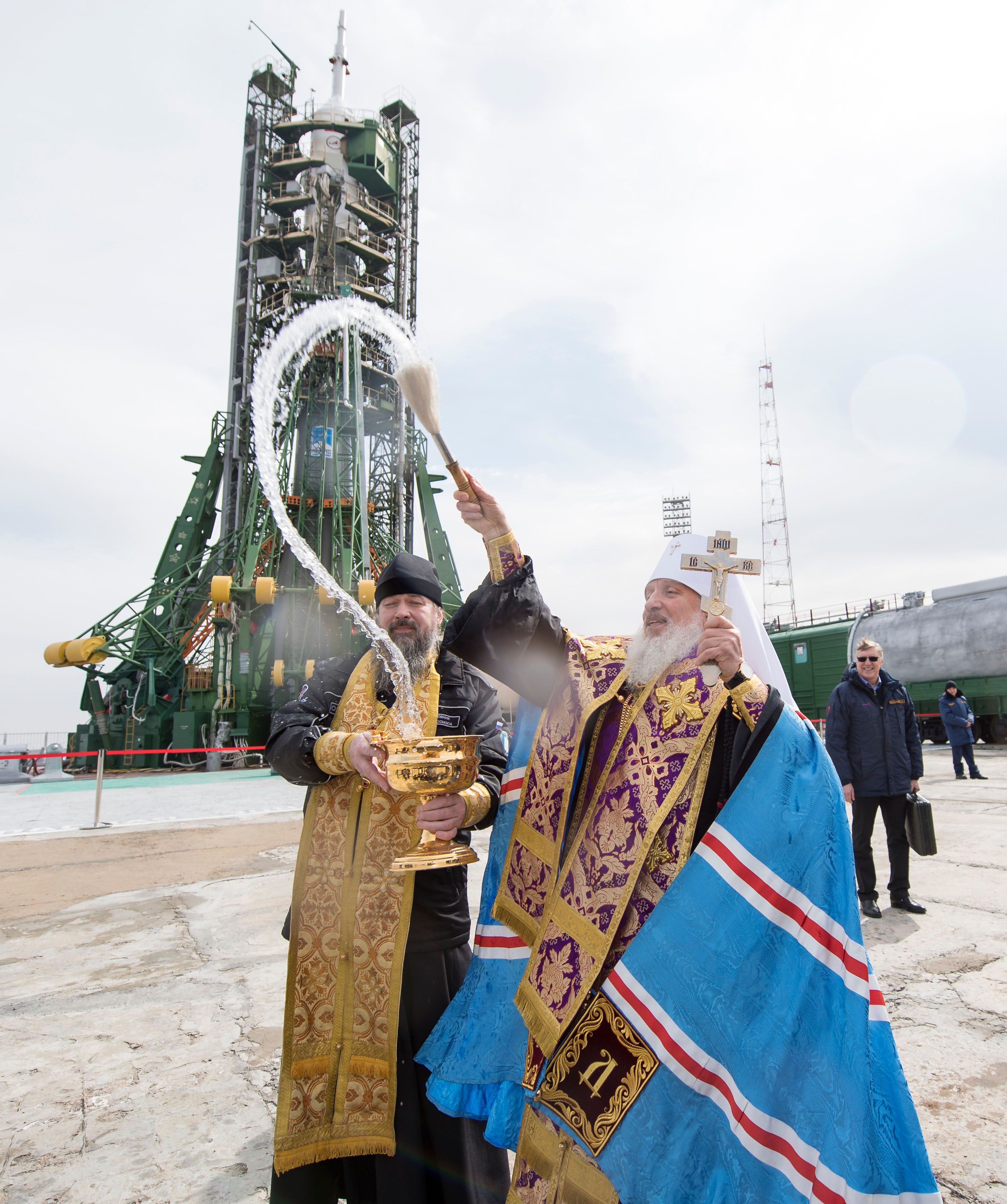 An Orthodox Priest blesses members of the media at the Baikonur Cosmodrome launch pad, Tuesday, March 20, 2018 in Baikonur, Kazakhstan. Expedition 55 Soyuz Commander Oleg Artemyev of Roscosmos, Ricky Arnold and Drew Feustel of NASA are scheduled to launch to the International Space Station aboard the Soyuz MS-08 spacecraft on Wednesday, March, 21.