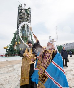 An Orthodox Priest blesses members of the media at the Baikonur Cosmodrome launch pad, Tuesday, March 20, 2018 in Baikonur, Kazakhstan. Expedition 55 Soyuz Commander Oleg Artemyev of Roscosmos, Ricky Arnold and Drew Feustel of NASA are scheduled to launch to the International Space Station aboard the Soyuz MS-08 spacecraft on Wednesday, March, 21.